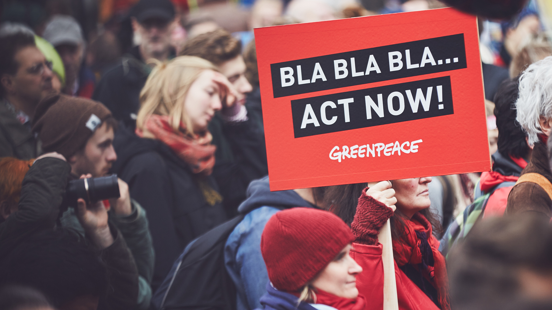 Manifestanti di Greenpeace con cartello "Act Now"