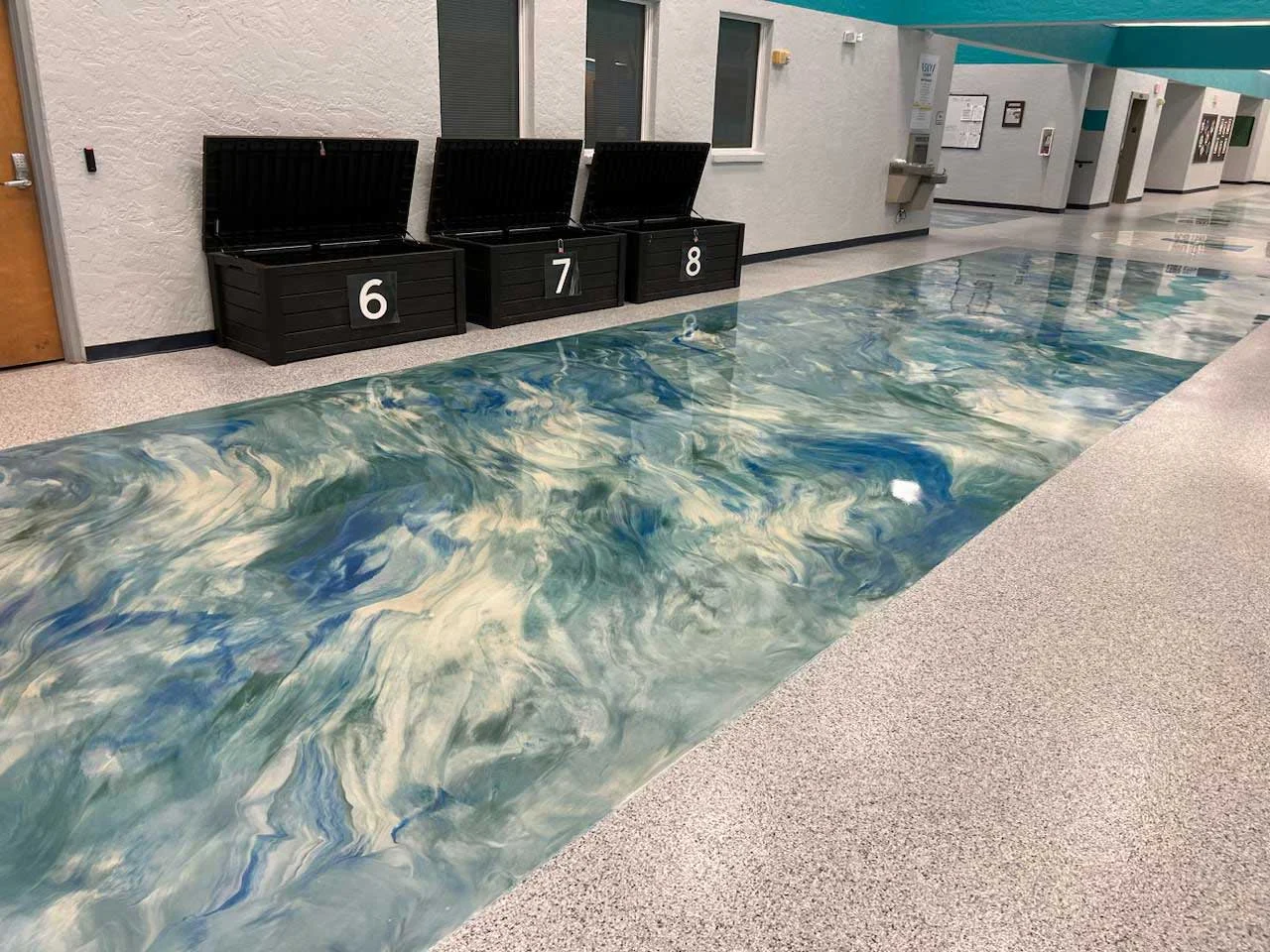 Metallic epoxy floor with numbered storage bins in a school hallway