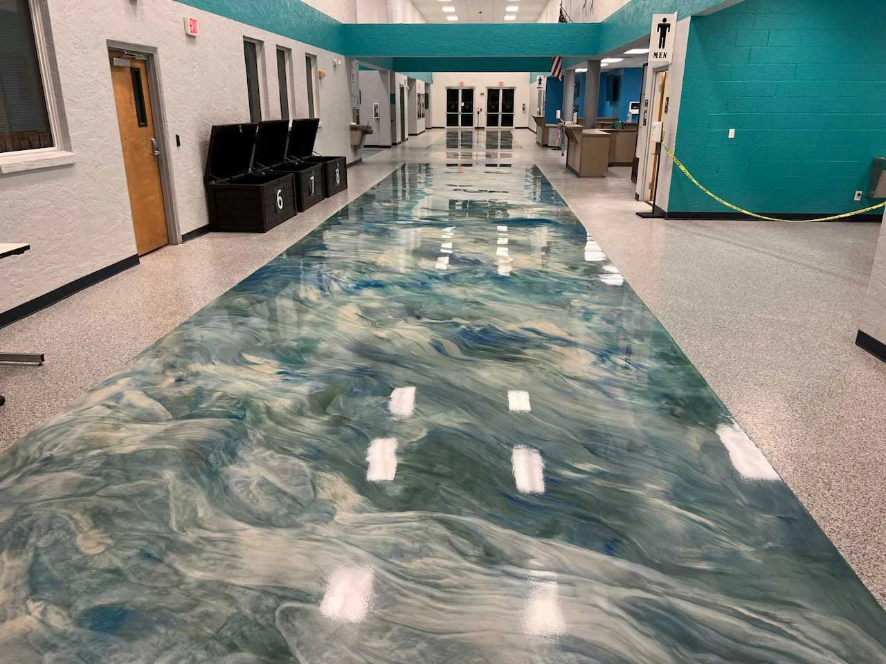 Metallic epoxy inlay in a school hallway beside a flake floor