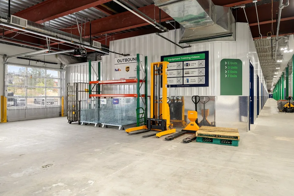WareSpace shared loading area with outbound carrier bins for FedEx, UPS, DHL, and Amazon next to a loading dock