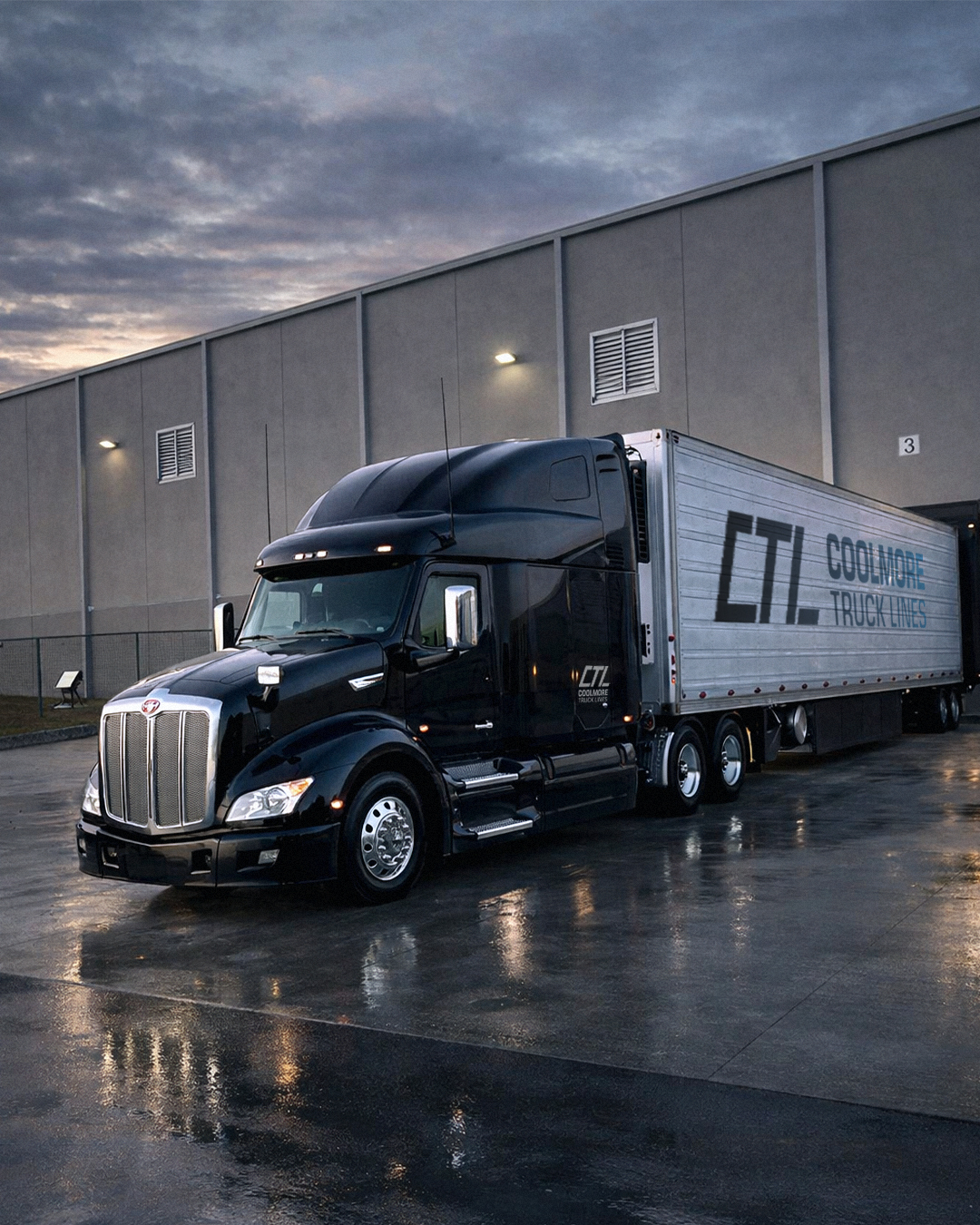Coolmore Truck Lines black Peterbilt with a CTL reefer at a warehouse dock at dusk