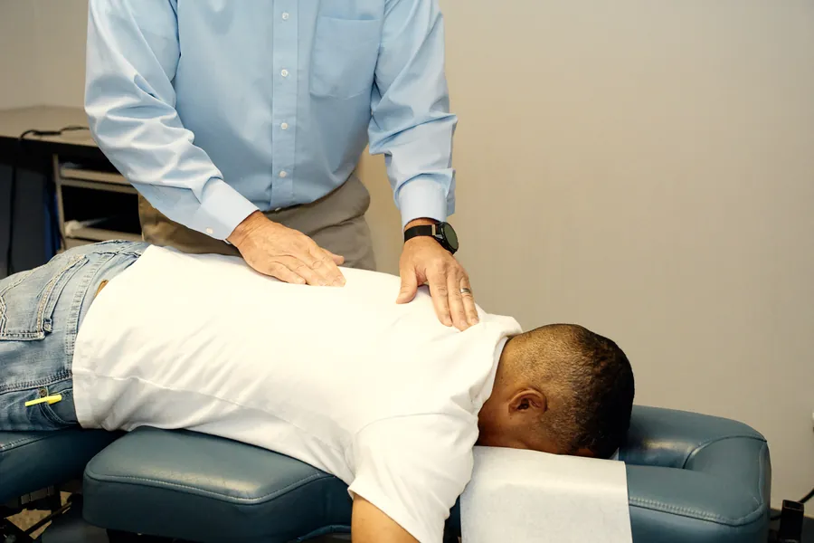 Dr. James Yager performing a manual chiropractic adjustment on a patient