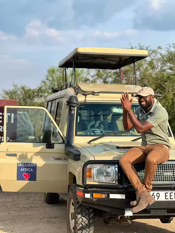 Brilliant Africa safari guide sitting on the bonnet of a safari vehicle