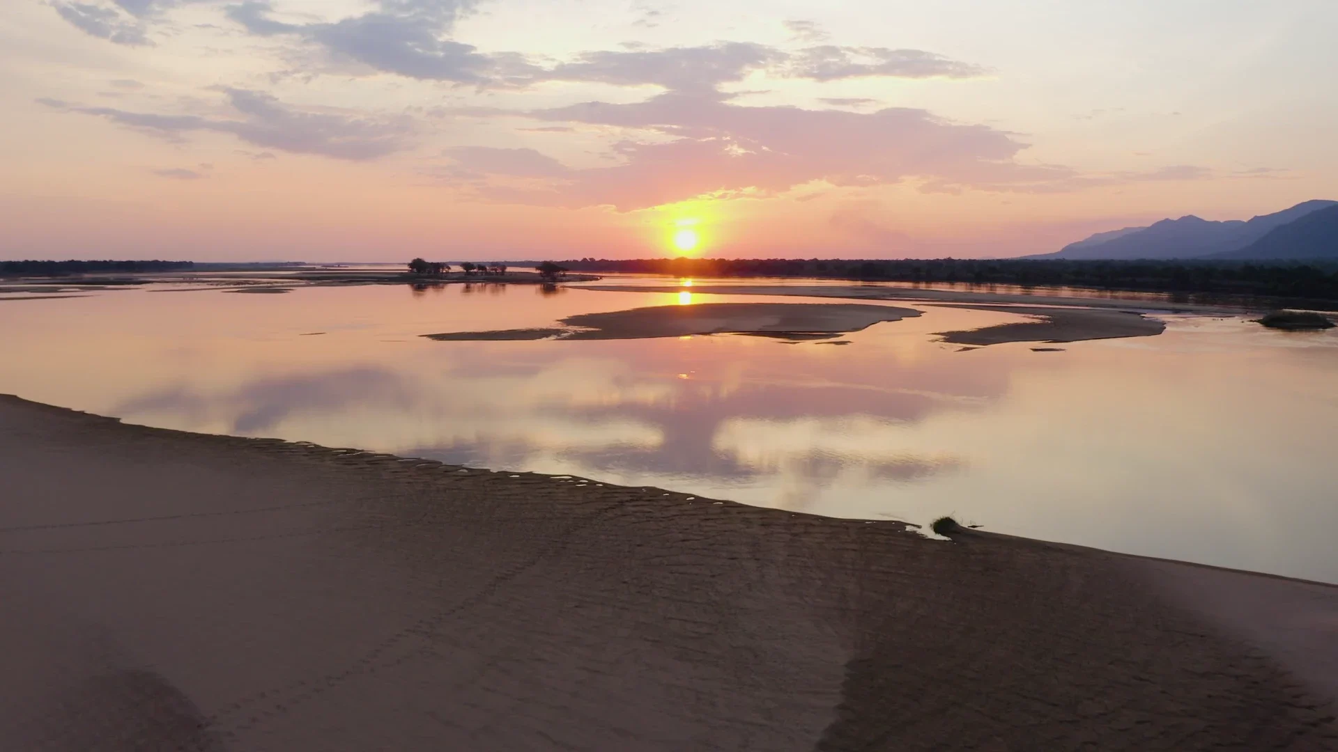 Sunset reflected across a wide river and sandy islands
