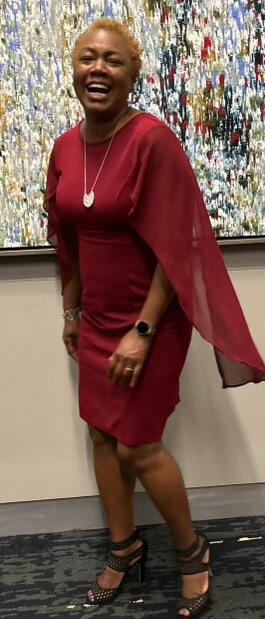 Dr. Williams laughing in a red dress