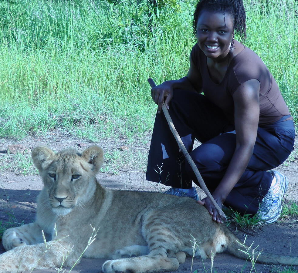 Dr. Williams kneeling beside a lion