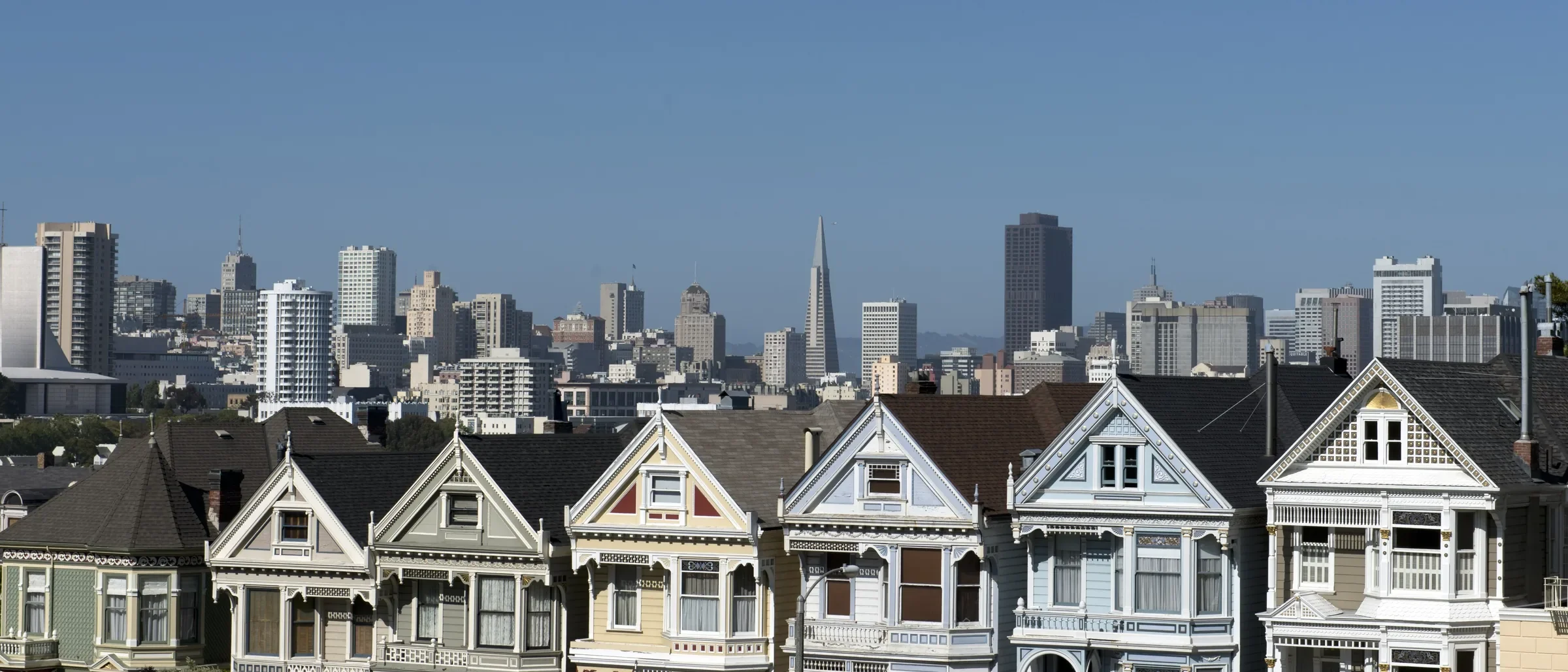 The Painted Ladies, a row of Victorian houses on Steiner Street across from Alamo Square, with the downtown San Francisco skyline behind them