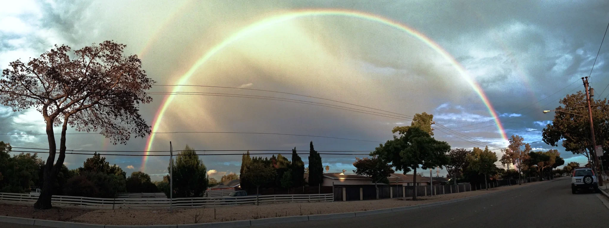 Double rainbow over a Newark street lined with single-story homes