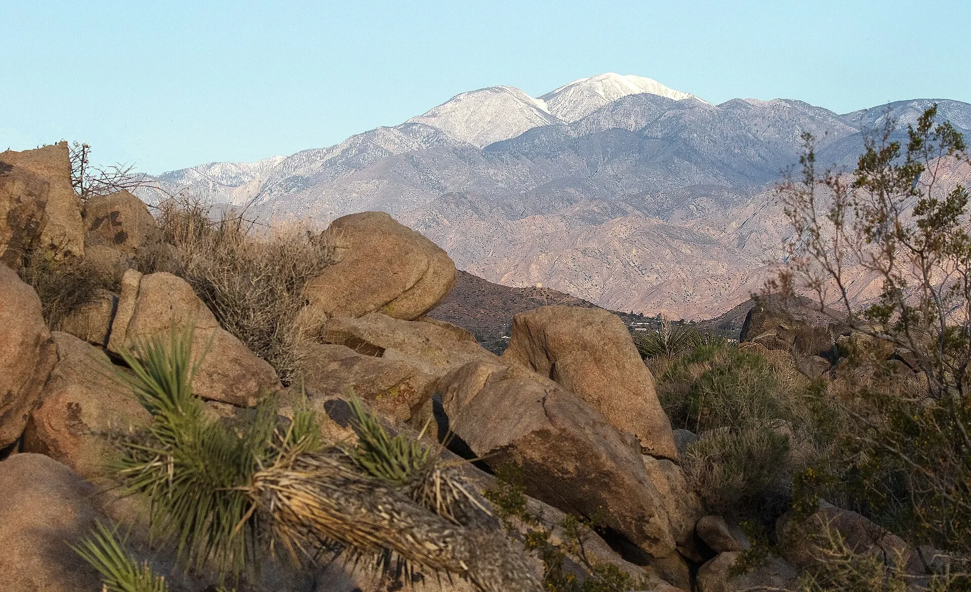 Snow-capped San Gorgonio Mountain rising above boulders and desert scrub, the peak that towers over Beaumont