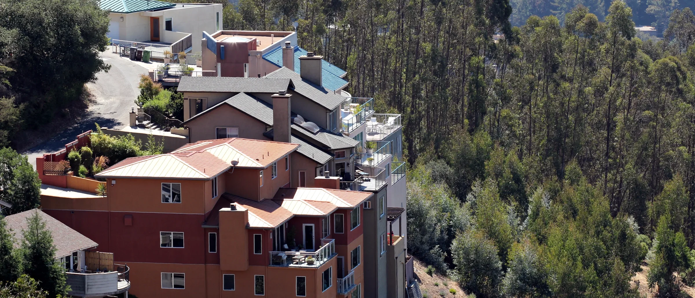 Multi-story homes stepping down a wooded hillside in the Oakland hills