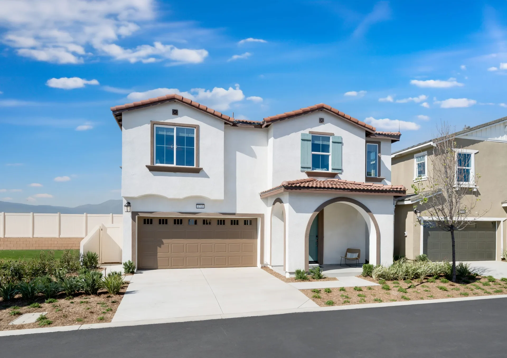 New two-story Lennar home with a tiled roof and arched entry at Renaissance in Rialto, California
