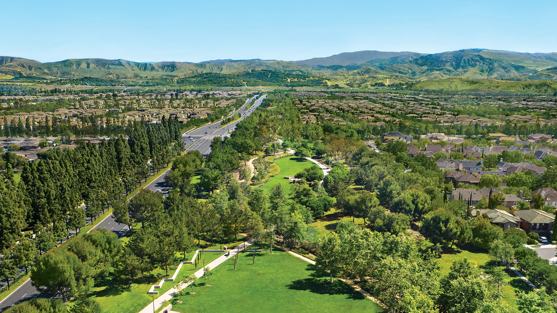 Aerial view of the Jeffrey Open Space Trail greenbelt running between Irvine neighborhoods toward the hills
