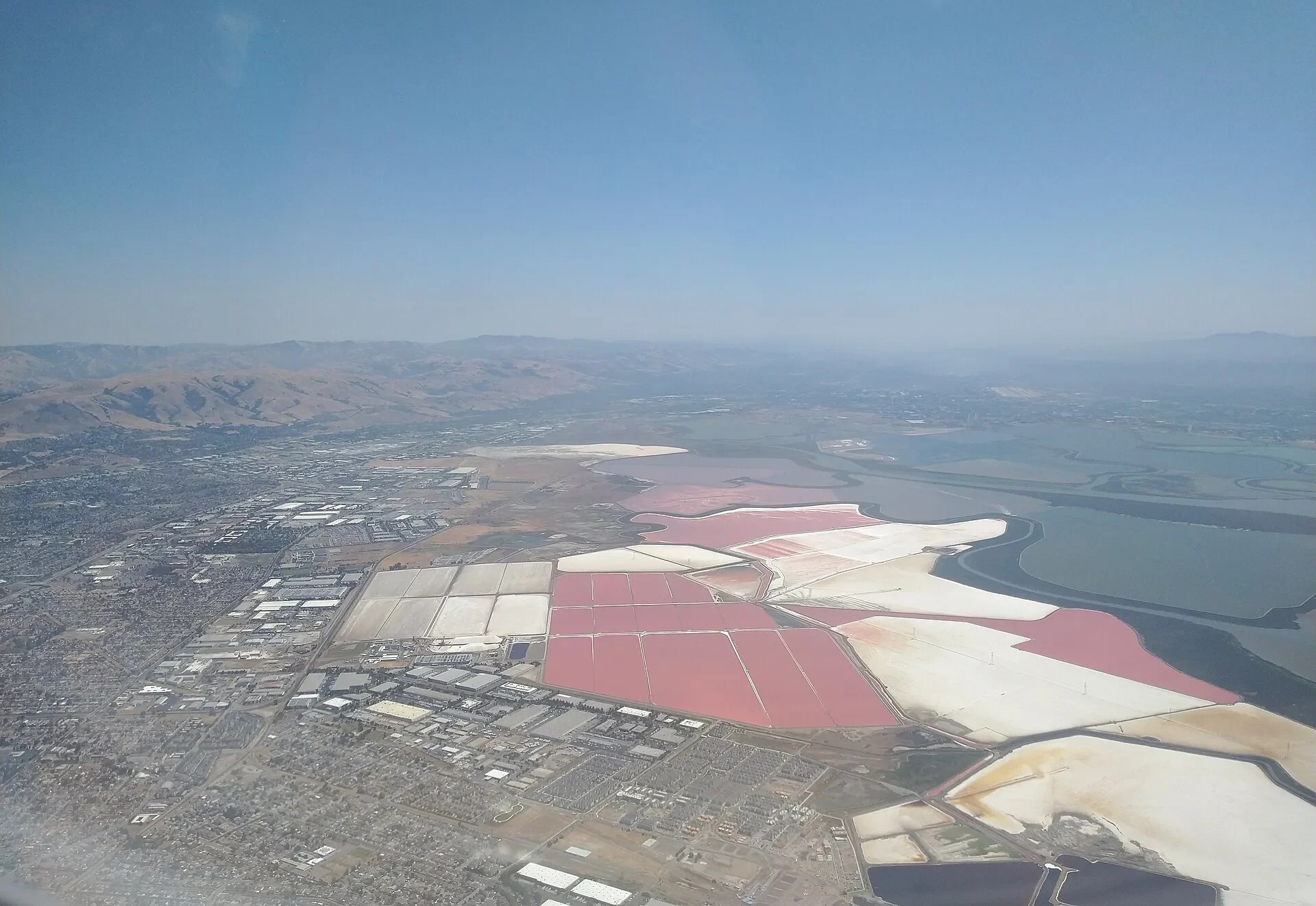 Aerial view of colorful salt ponds along the bay next to Newark, California