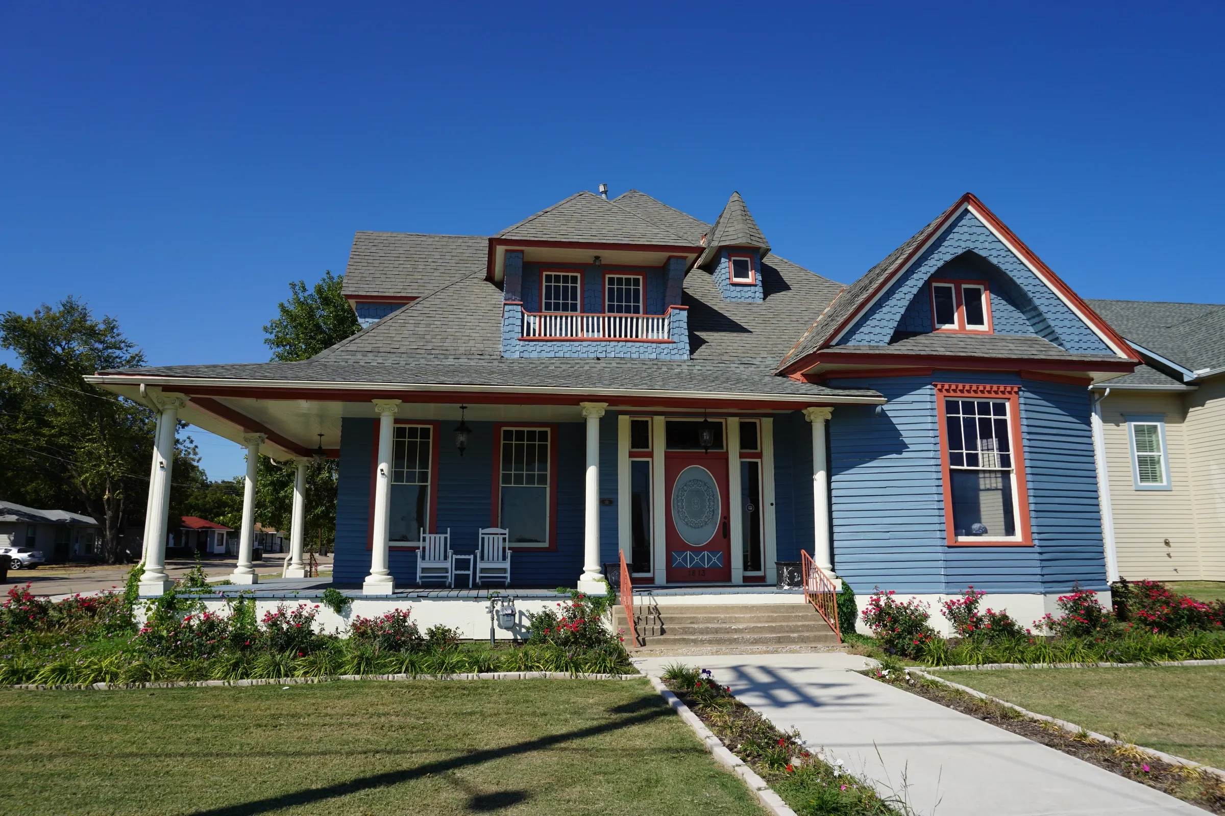 Blue Victorian house with a wide white-columned front porch in Downtown Plano