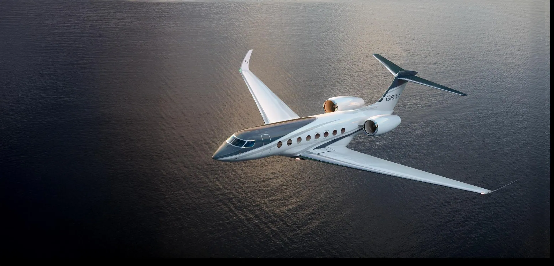 Long-range private jet wing over open ocean on a global charter