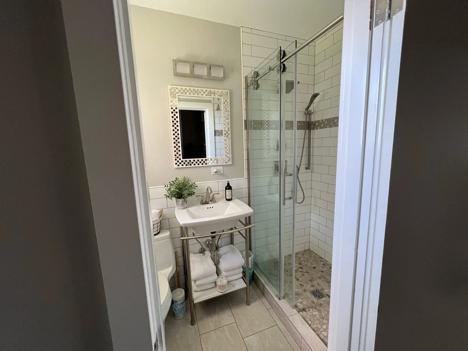 Bathroom with a glass-enclosed shower and pebble shower floor