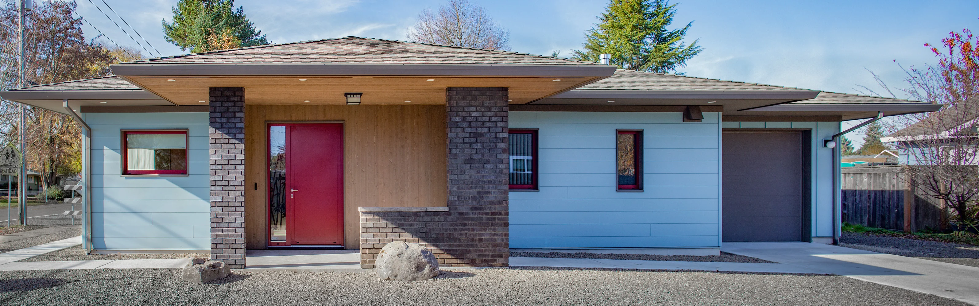 Mau Passive House, a single-story Birdsmouth design-build home with blue siding and a red door