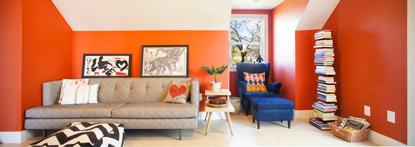 Orange-walled Birdsmouth living room with sofa and blue armchair