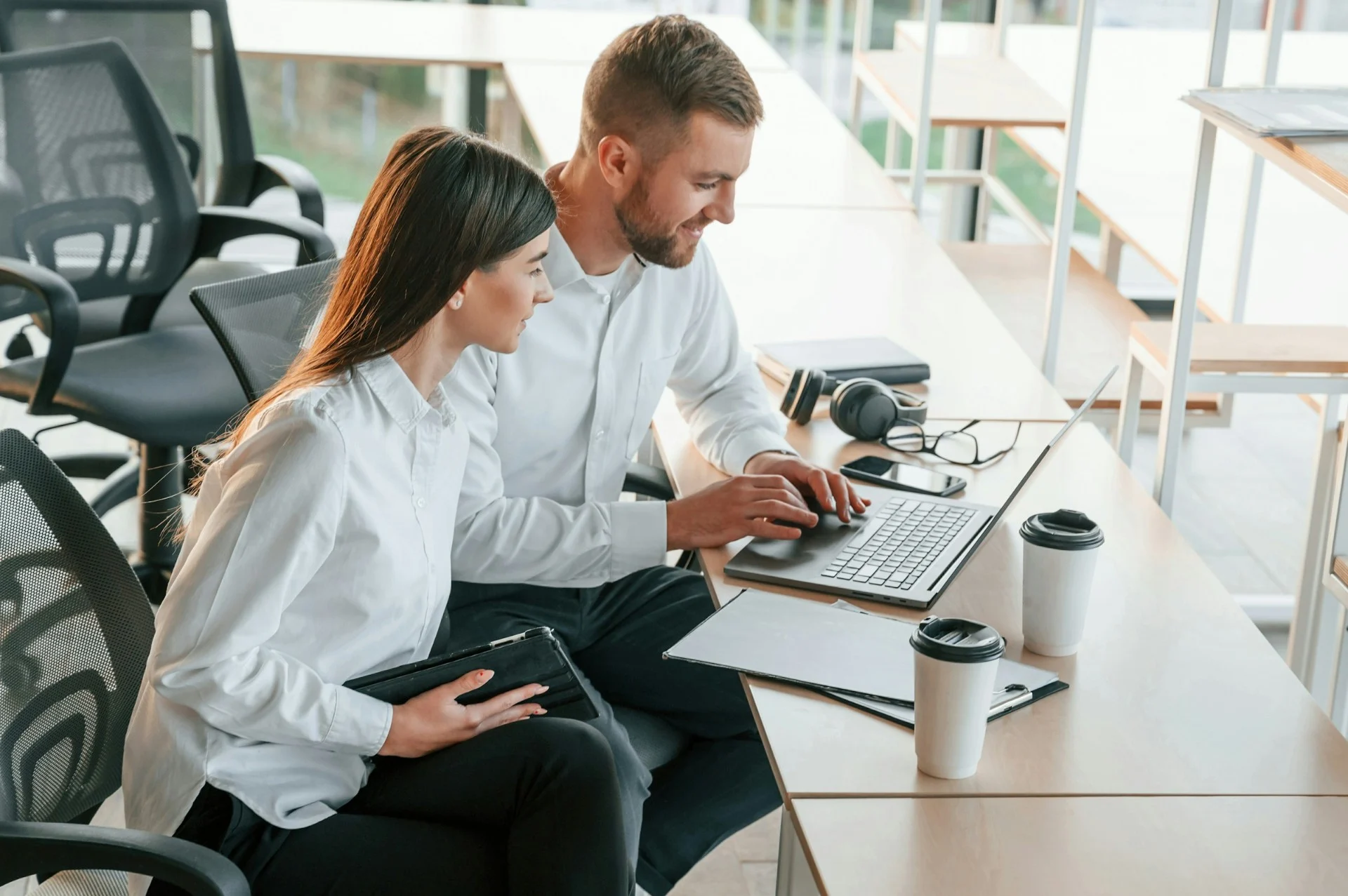 Zakelijke professionals die samenwerken aan projectwerk in modern kantoor