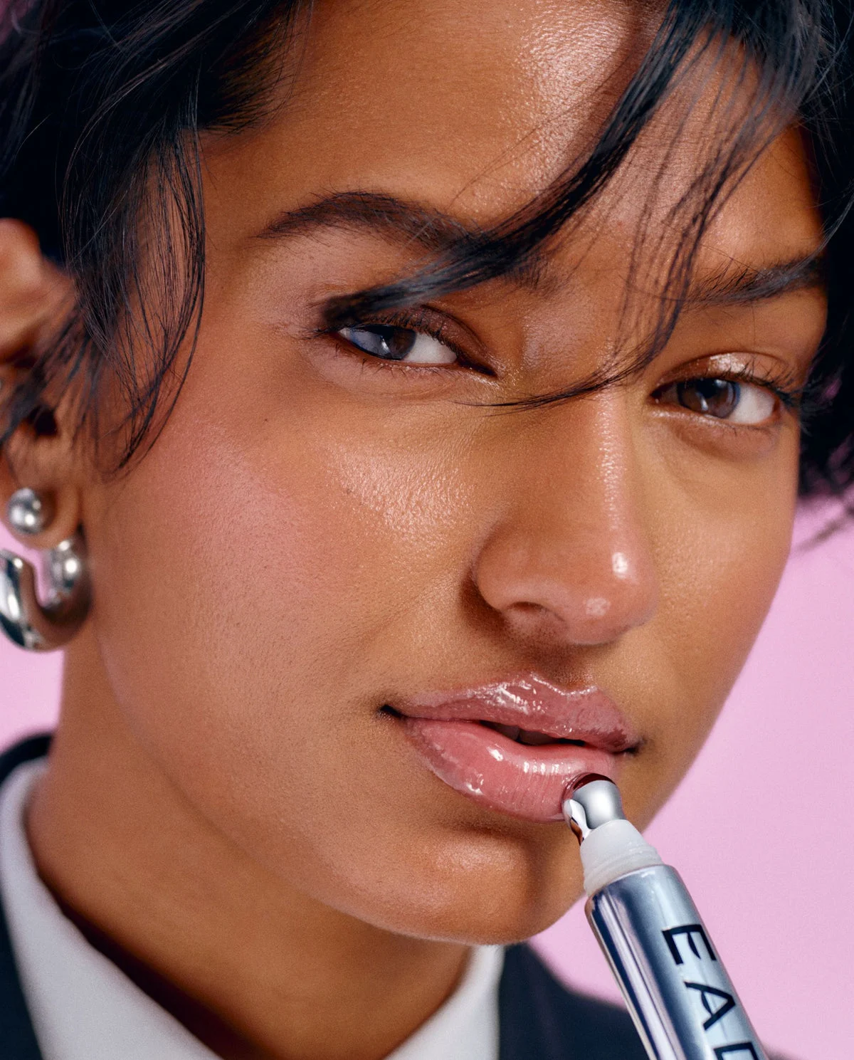 A woman applying EADEM Le Chouchou lip balm