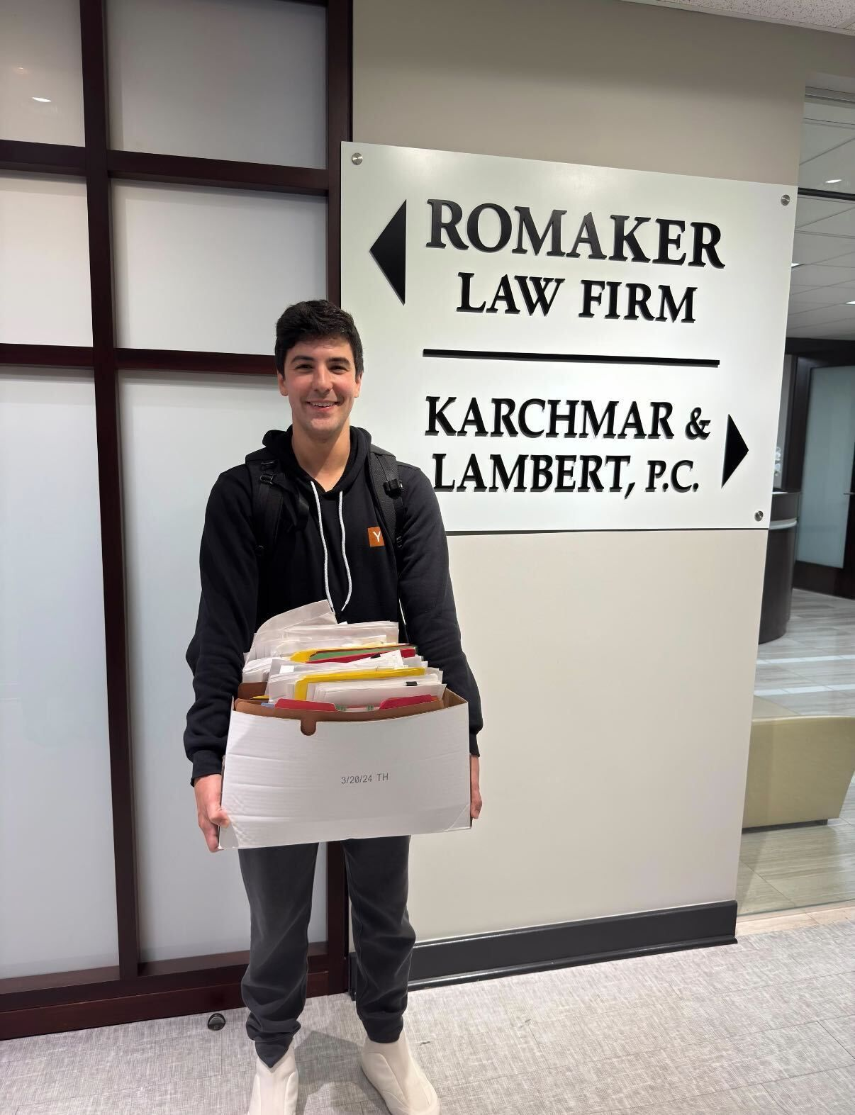 Andco team member delivering a box of case files at a law firm