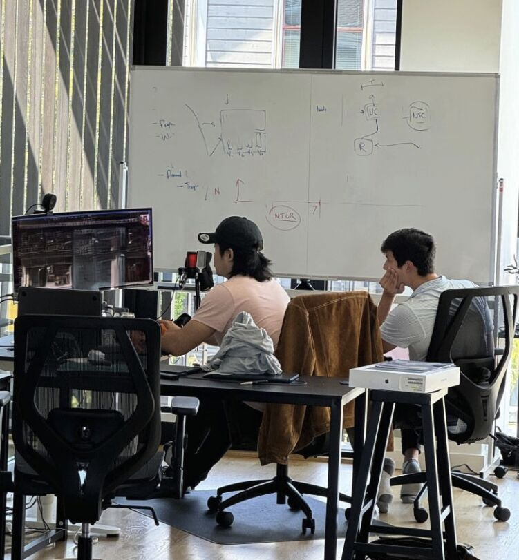 Andco teammates working beside a product whiteboard