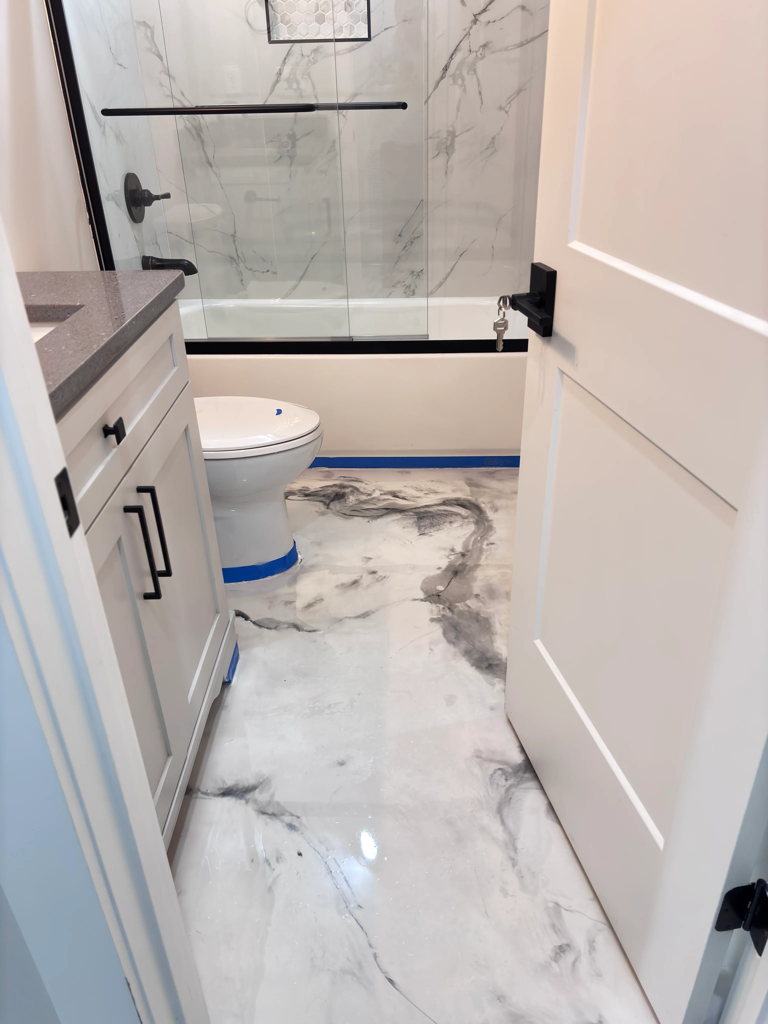 Gray marble-effect epoxy floor in a renovated bathroom