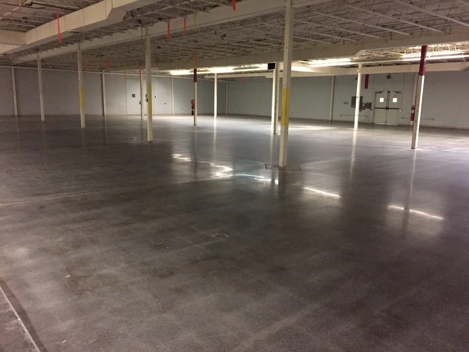 Gray concrete floor in an empty industrial room with support columns