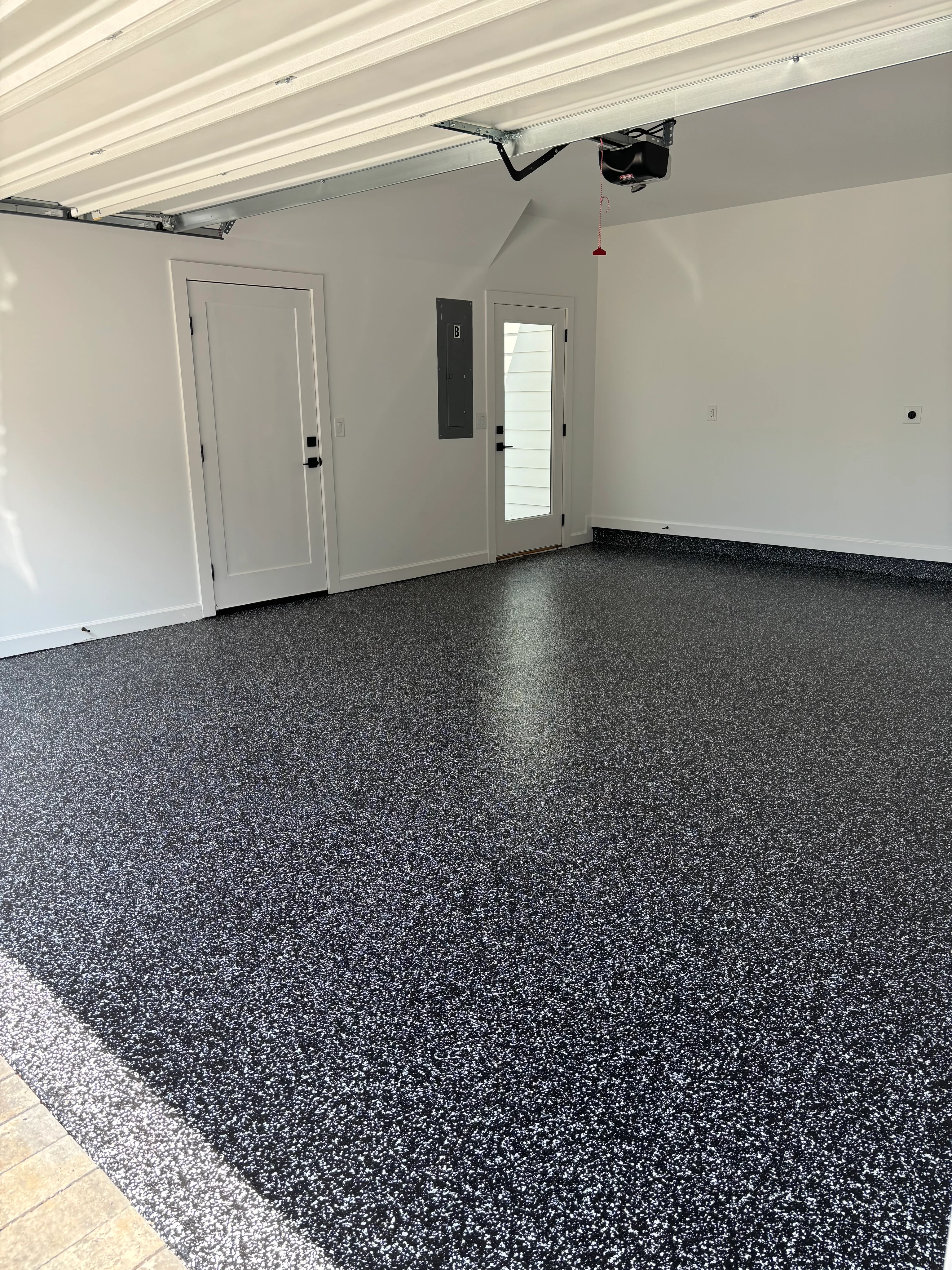 Dark gray speckled epoxy floor in a white garage
