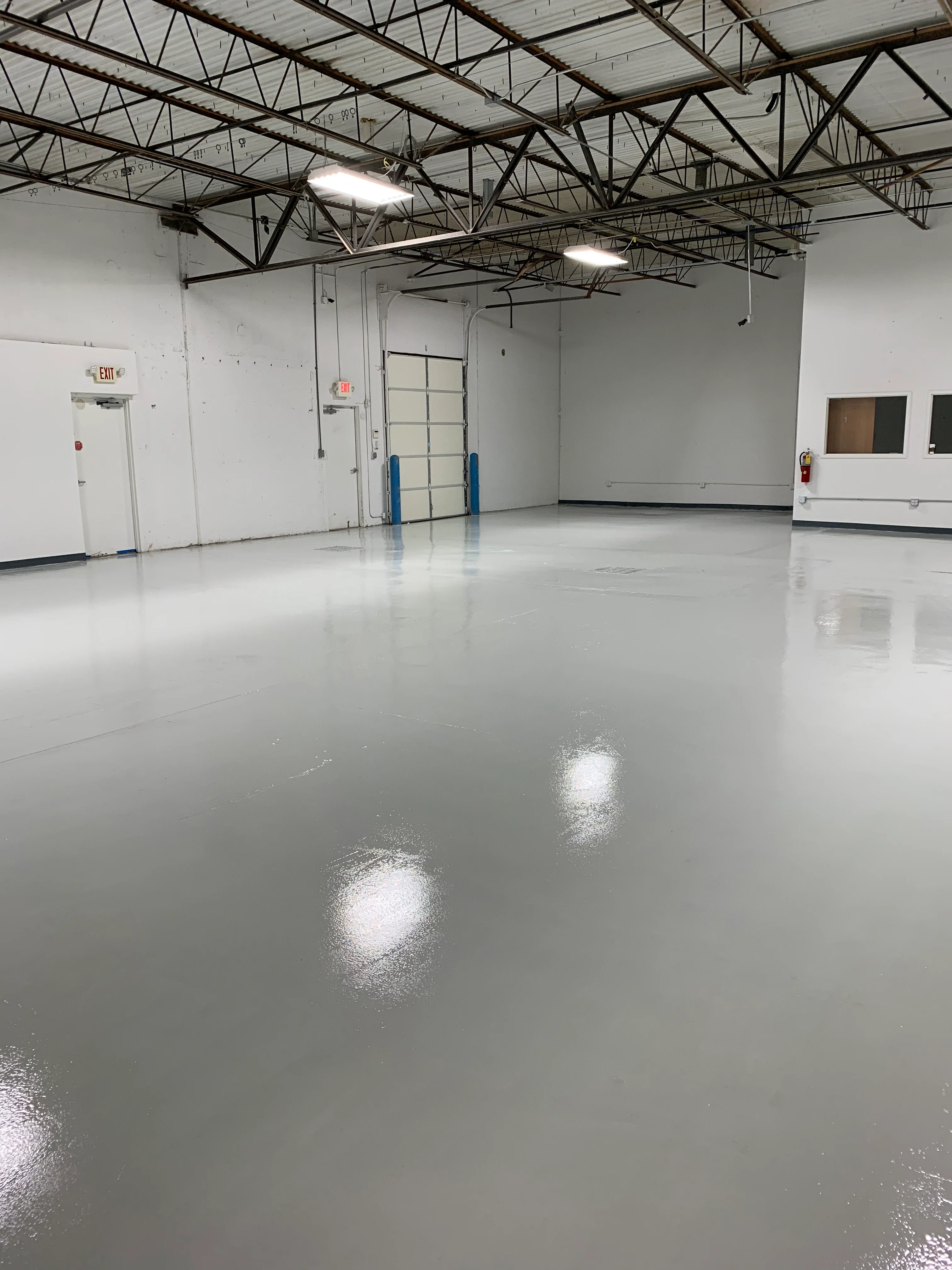 Concrete Masters v2 Reflective gray coated floor in an industrial warehouse