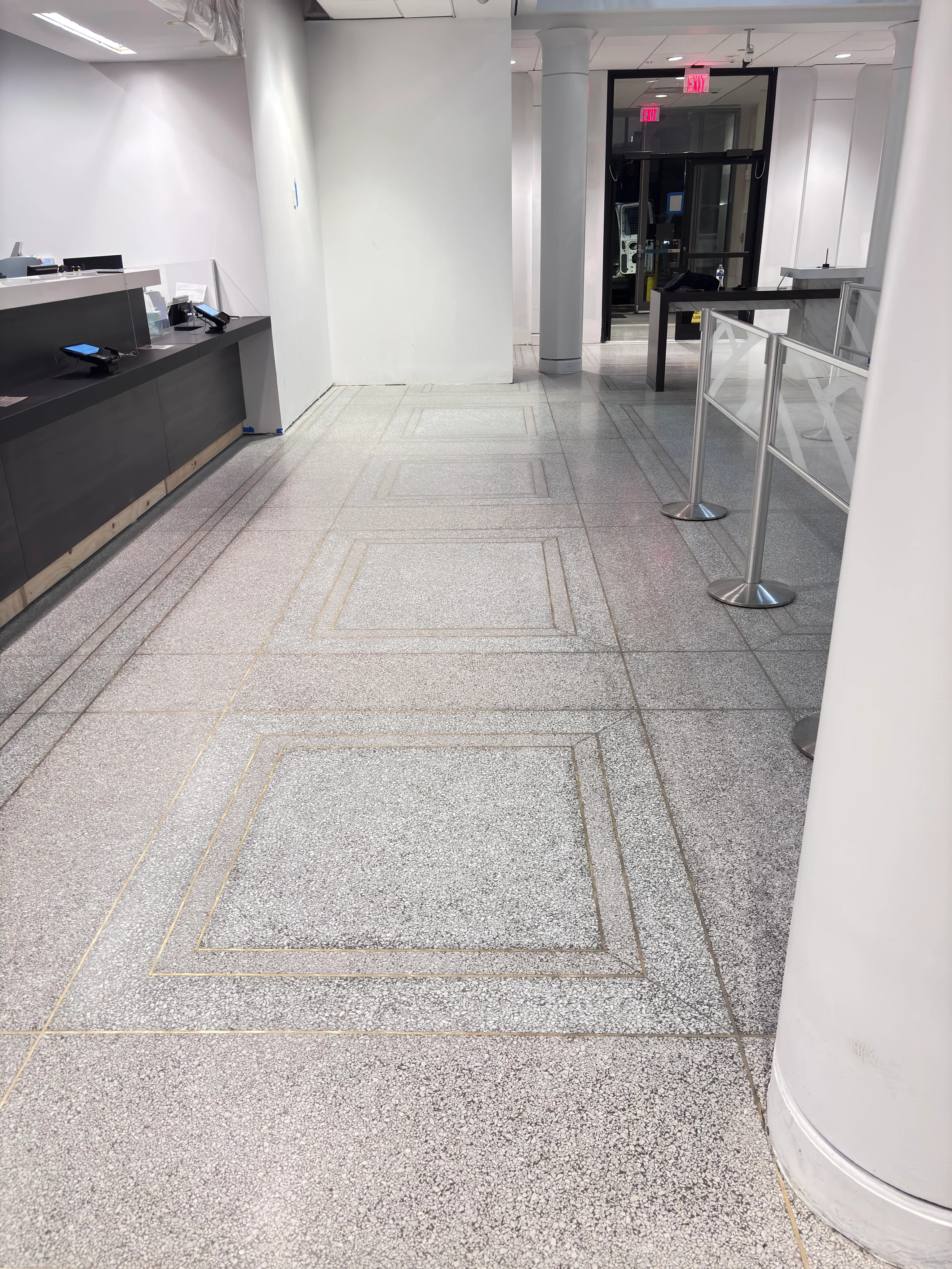 Gray terrazzo floor with brass inlays in a commercial lobby