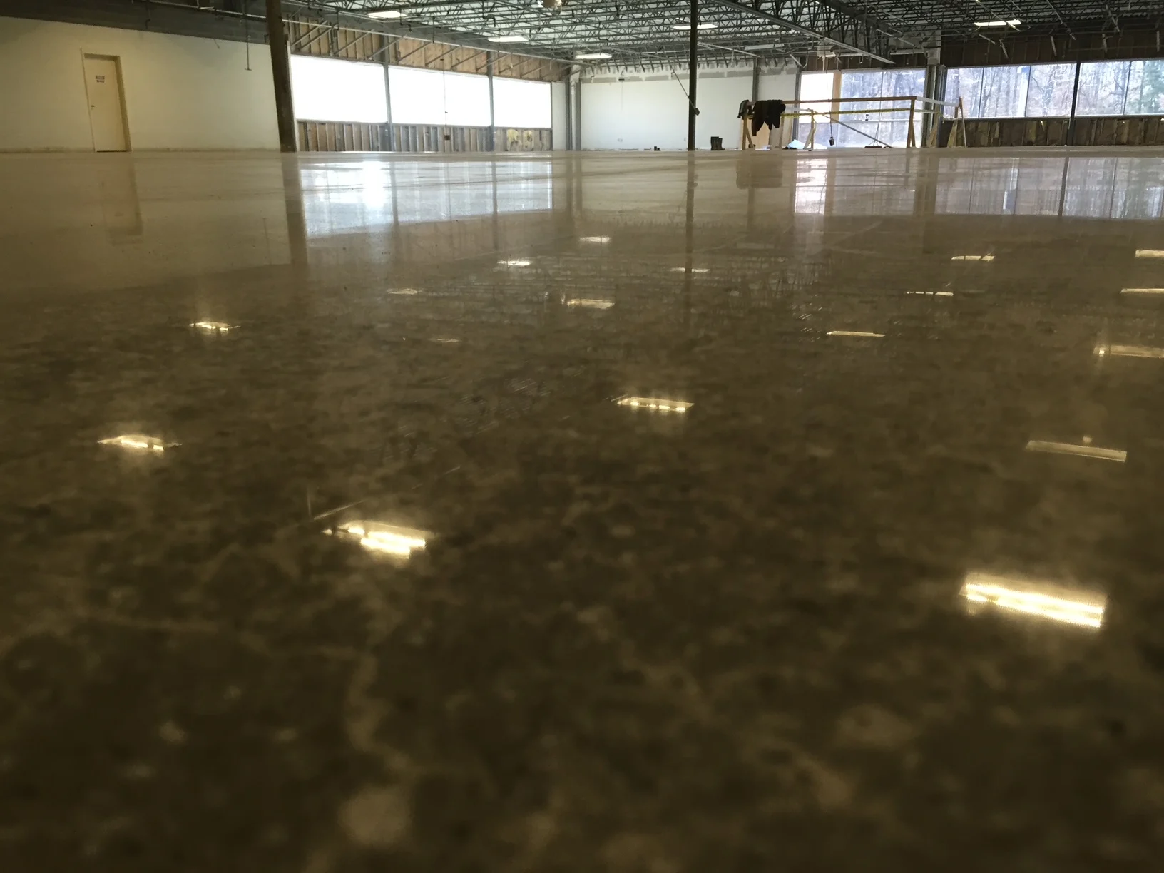 Low-angle view of a reflective floor in a commercial space under renovation