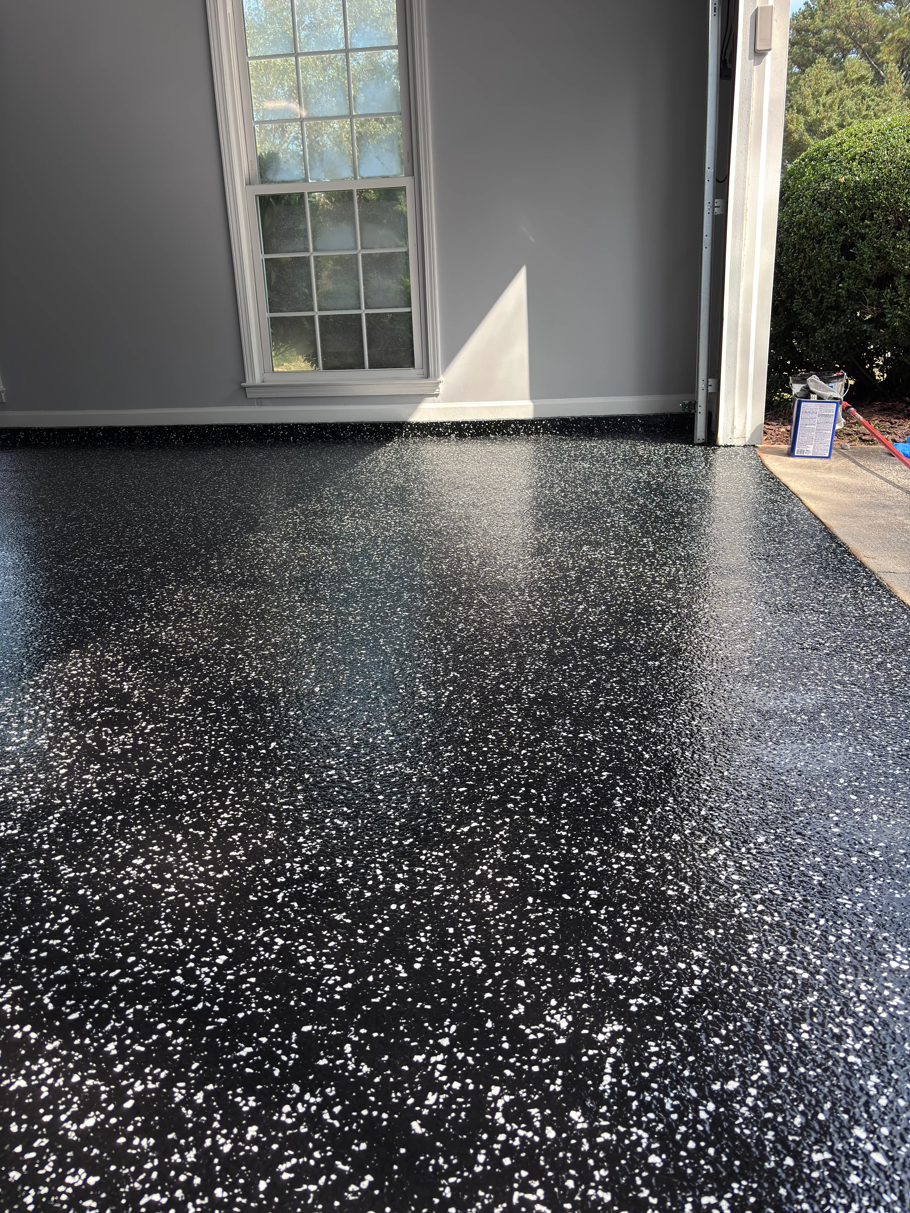 Black epoxy garage floor with white decorative flakes