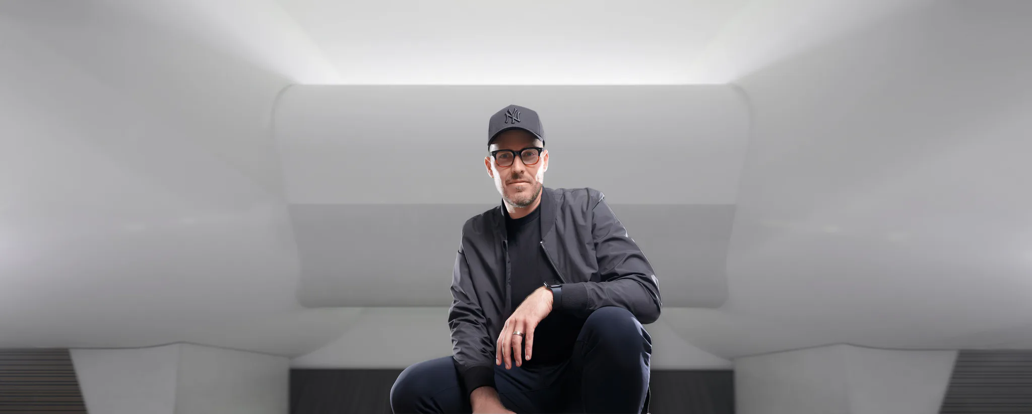 Coach Leighroy seated beneath a sculptural white ceiling