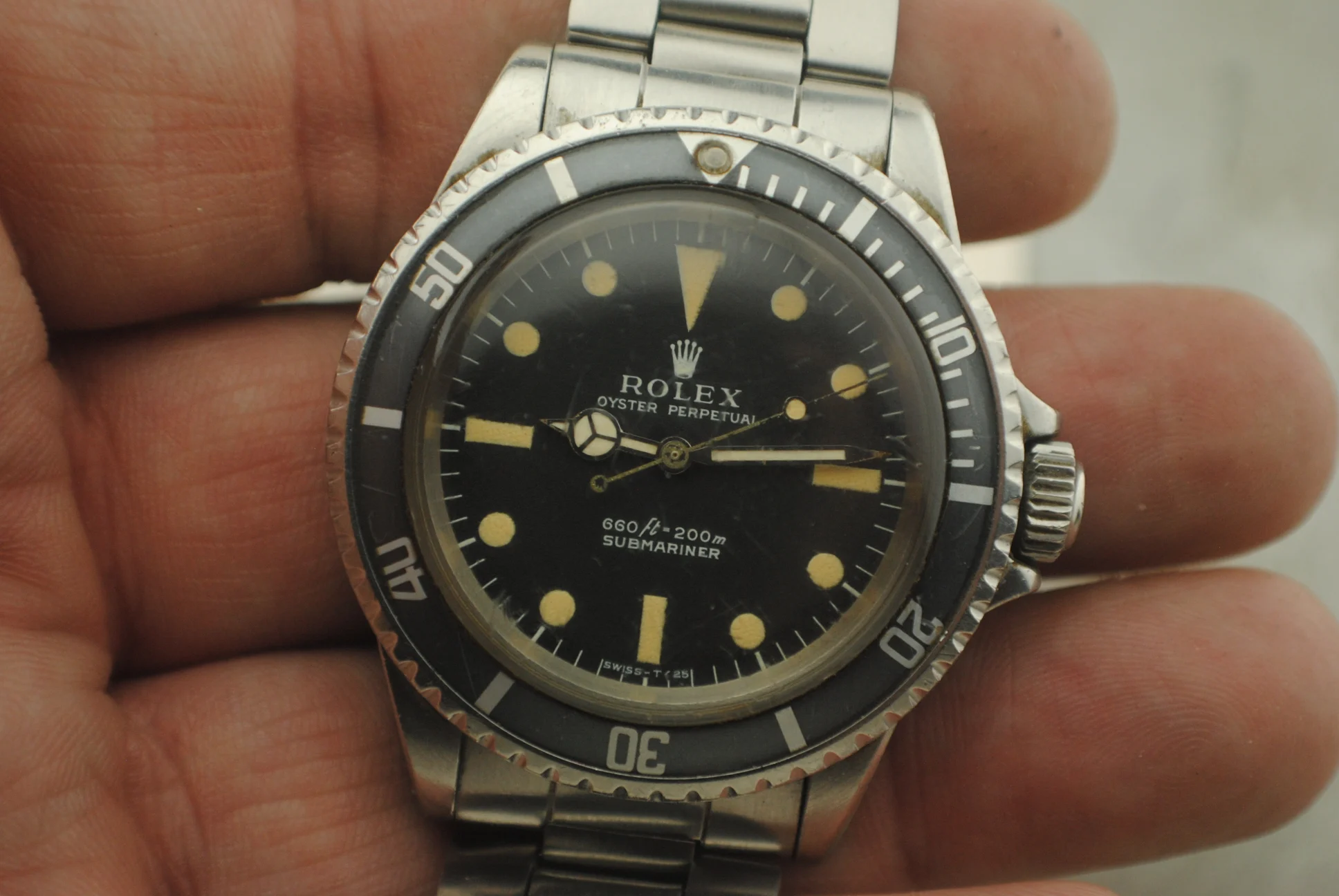 Closer crystal-on view of the Rolex Submariner 5513 showing its matte feet-first dial, patina, hands and bezel insert