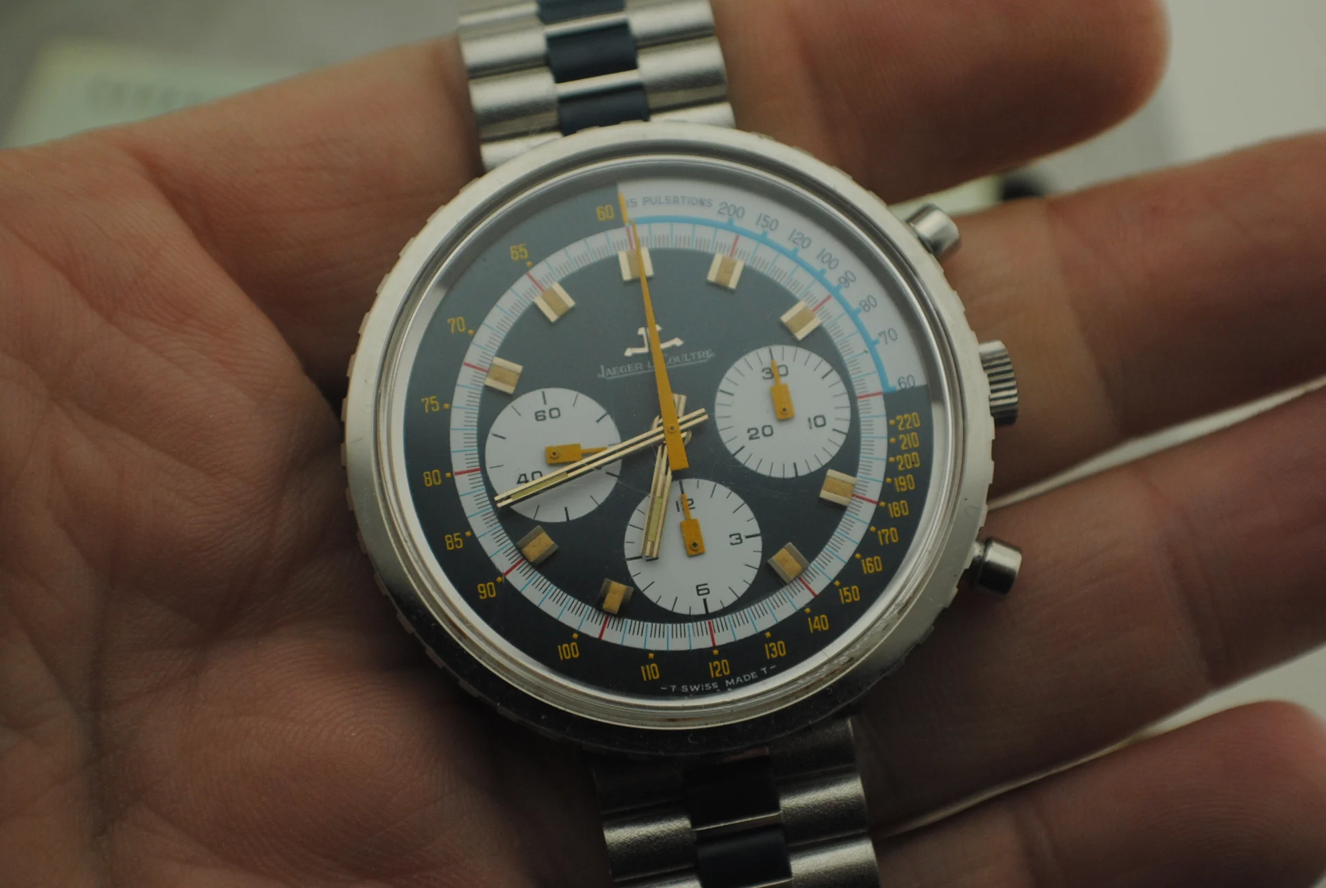 Crystal-on front view in hand of the Jaeger-LeCoultre Doctor Pulso showing its three white registers, yellow hands and blue pulsometer scale