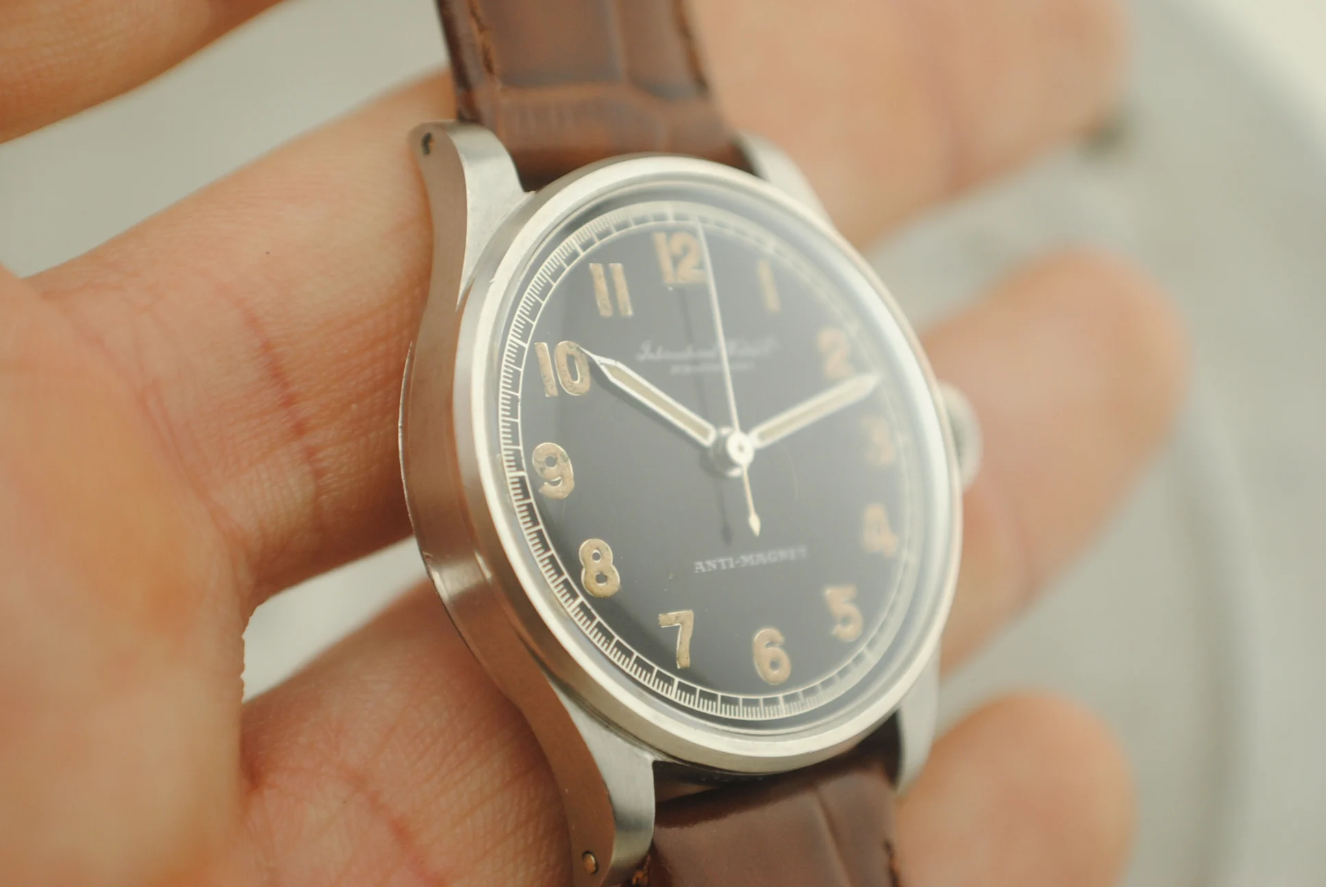 Angled crystal-on hand view of the IWC Calatrava Hermet showing its case profile, lugs and dial