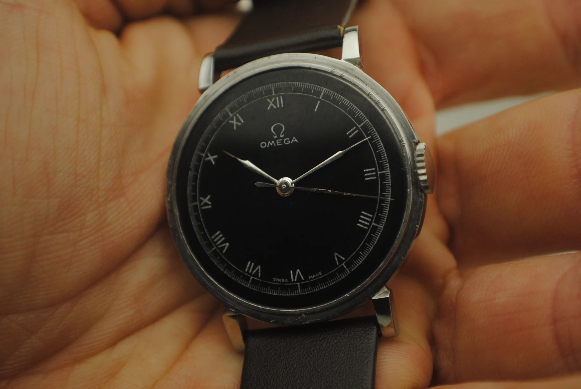 Close crystal-on view of the Omega CK2015 Fagiolino black enamel decalque dial