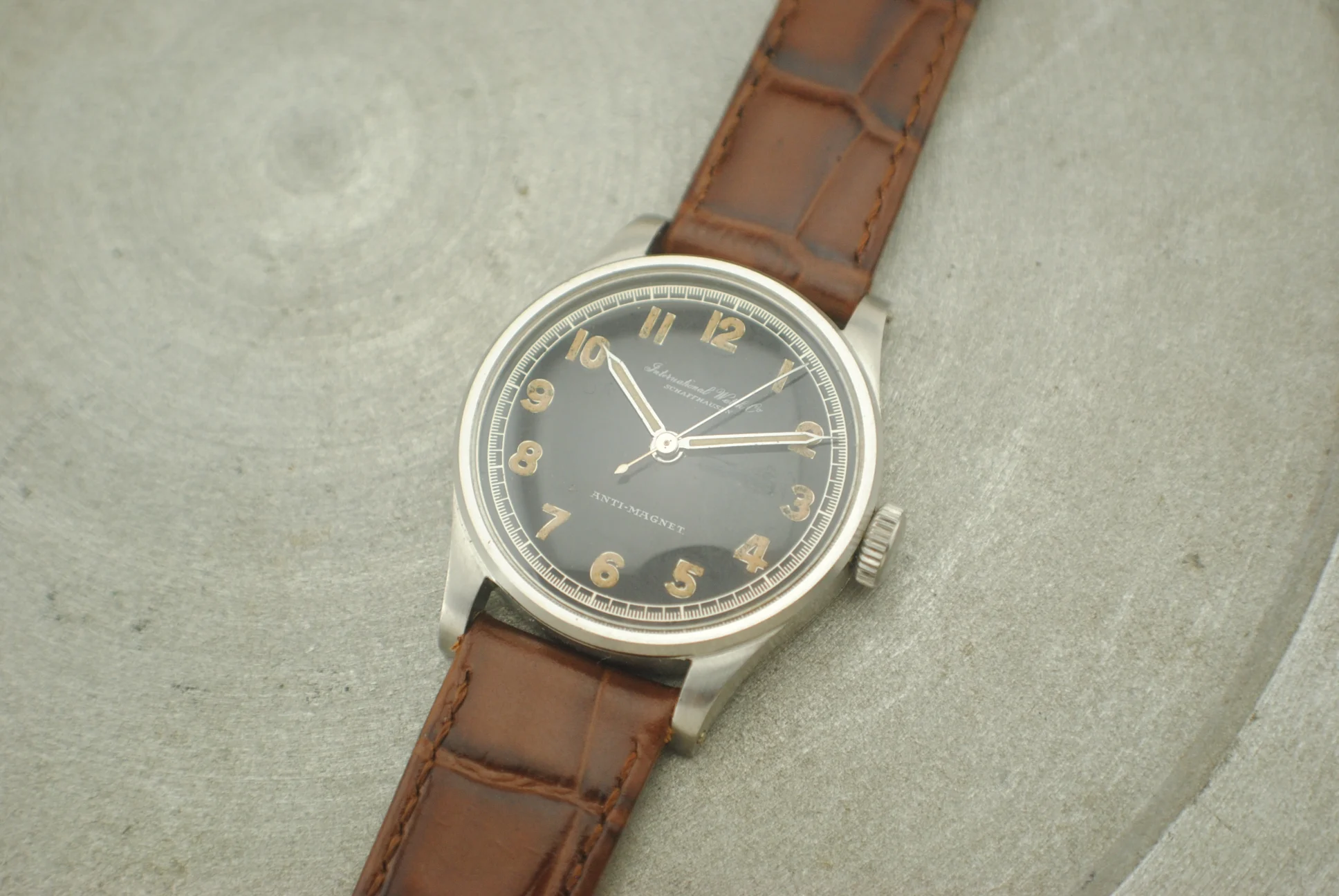 Alternate crystal-on workshop front of the IWC Calatrava Hermet with black dial and brown leather strap