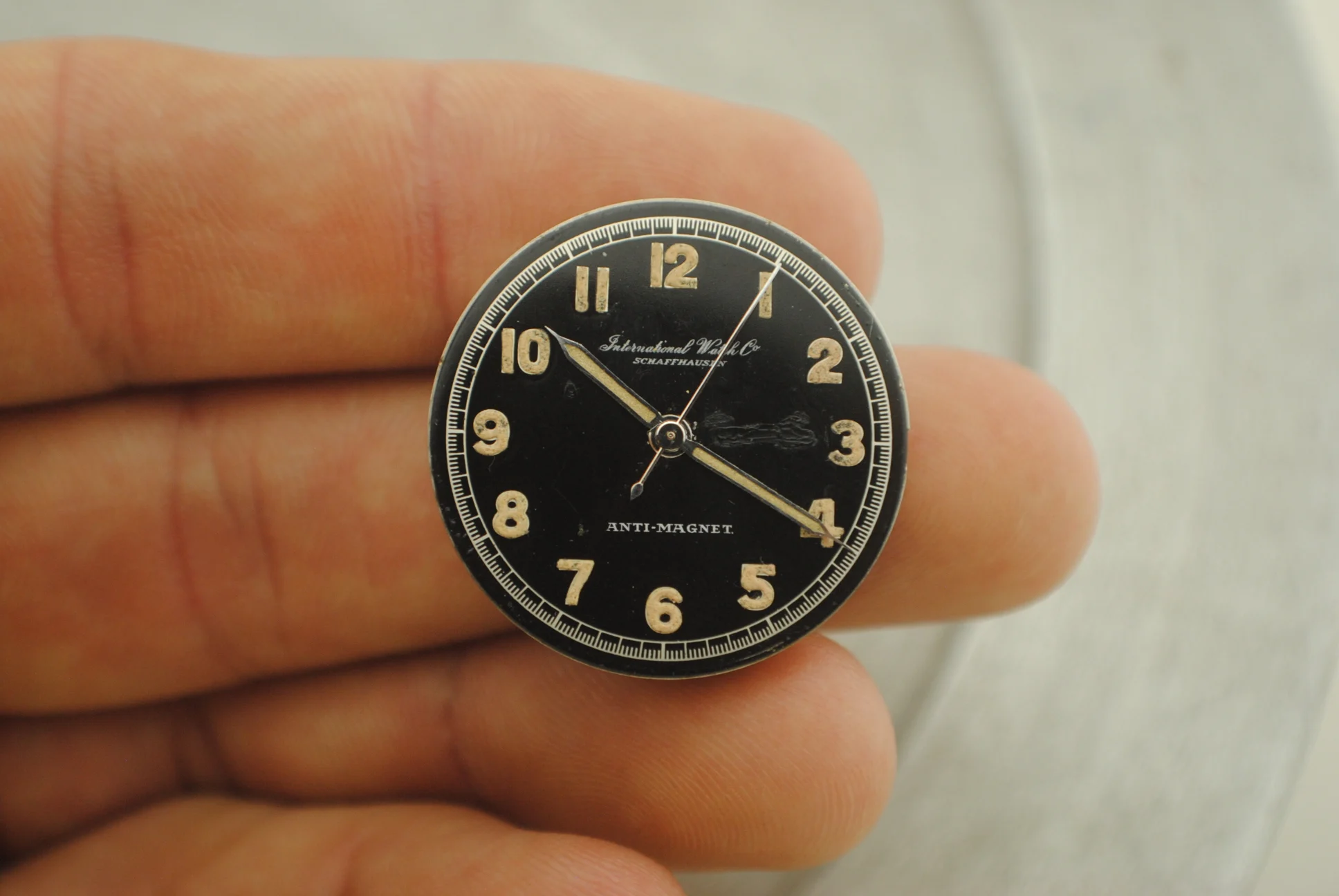 Uncased IWC dial detail showing radium Arabic numerals, galvanic outer track and the disclosed lacquer repair area
