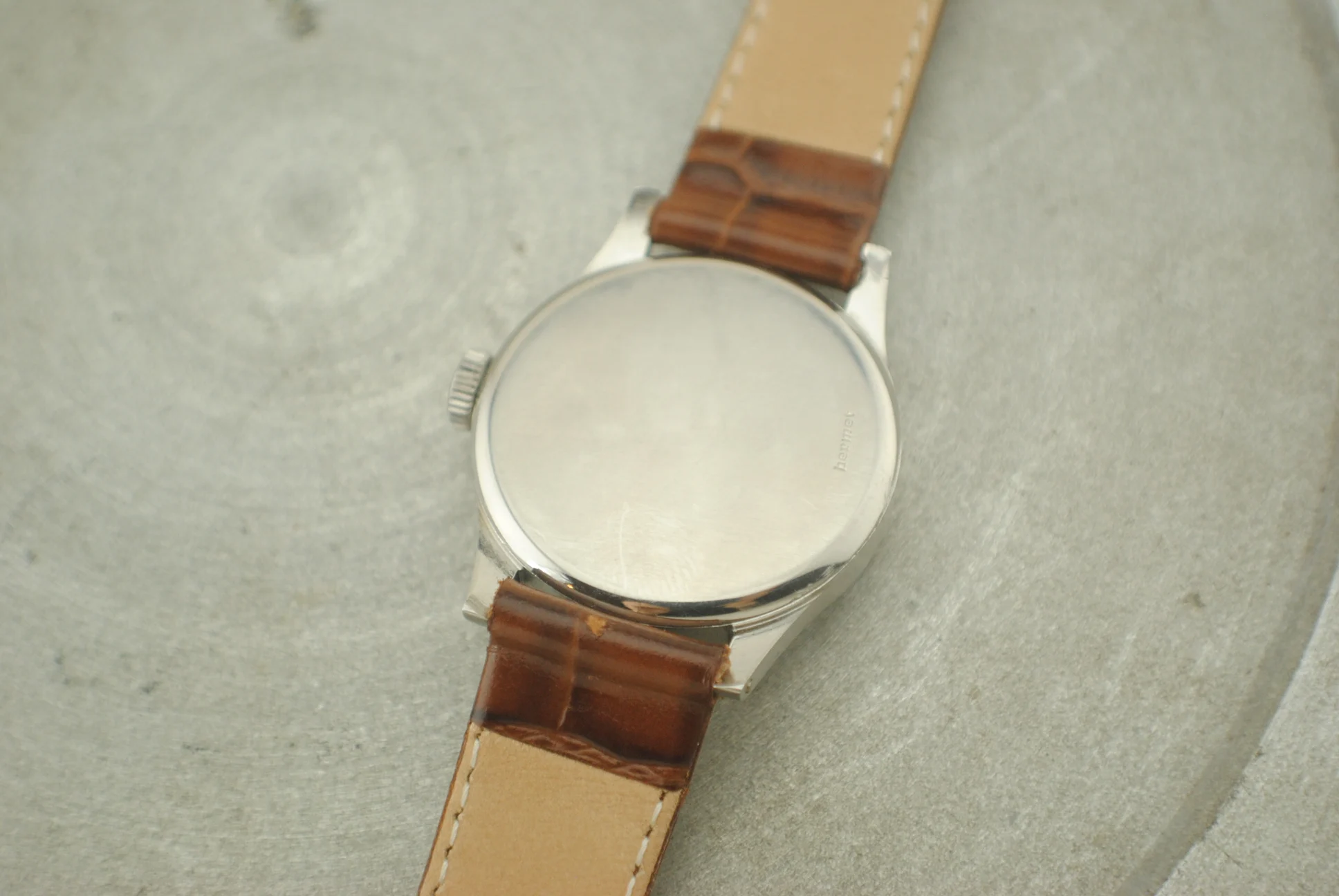 Closed caseback of the IWC Calatrava Hermet with Hermet engraving and brown leather strap