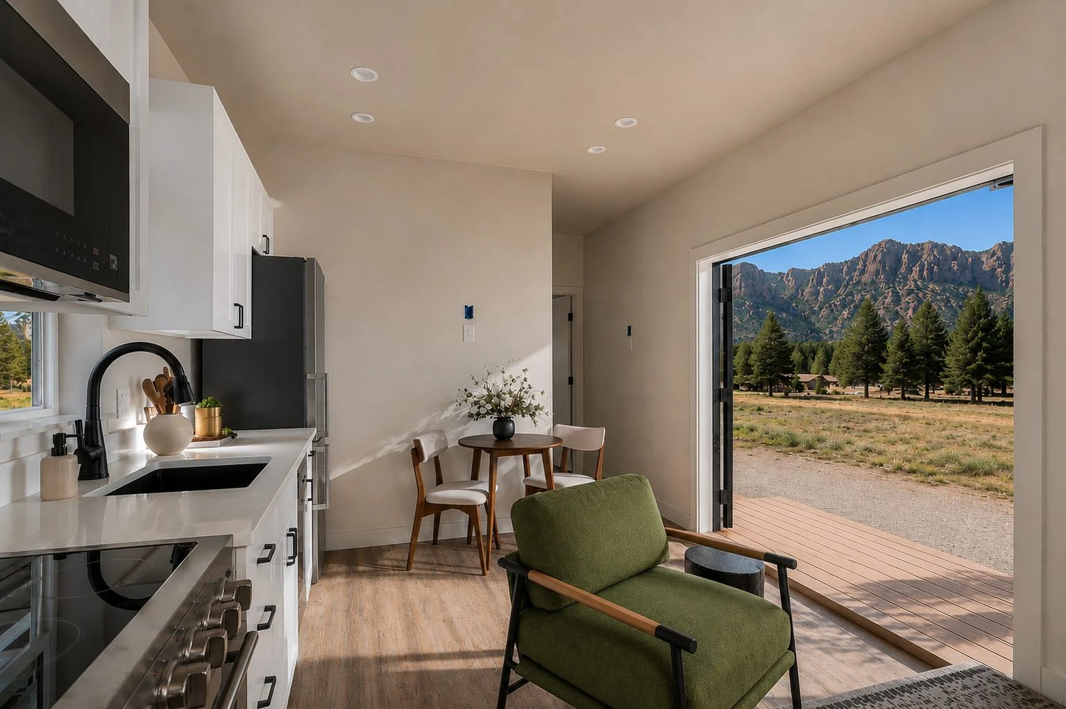 Basecamp kitchen and green armchair beside open doors facing the mountains