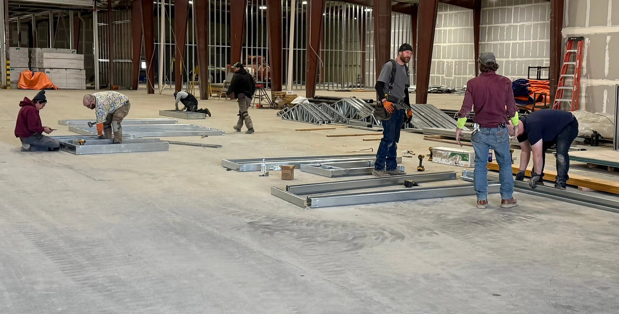 Crew assembling steel framing across the factory floor