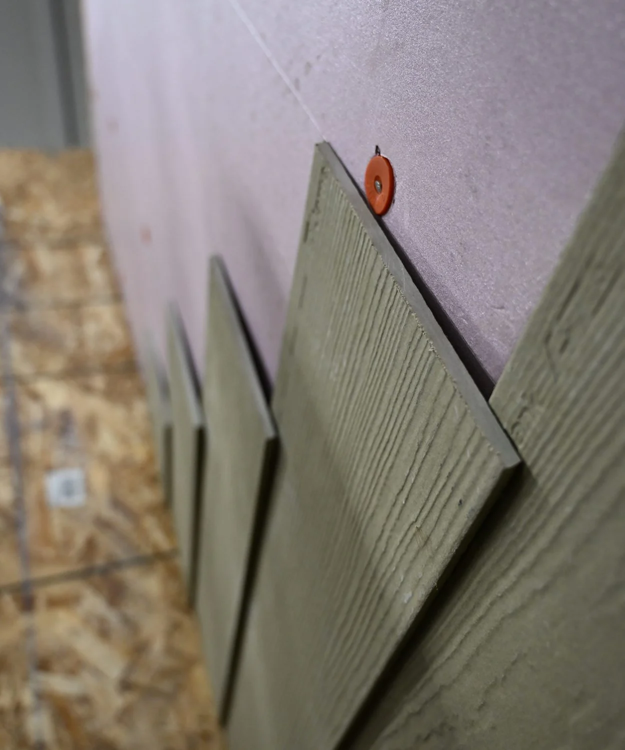 Textured siding boards installed over a rigid insulation panel