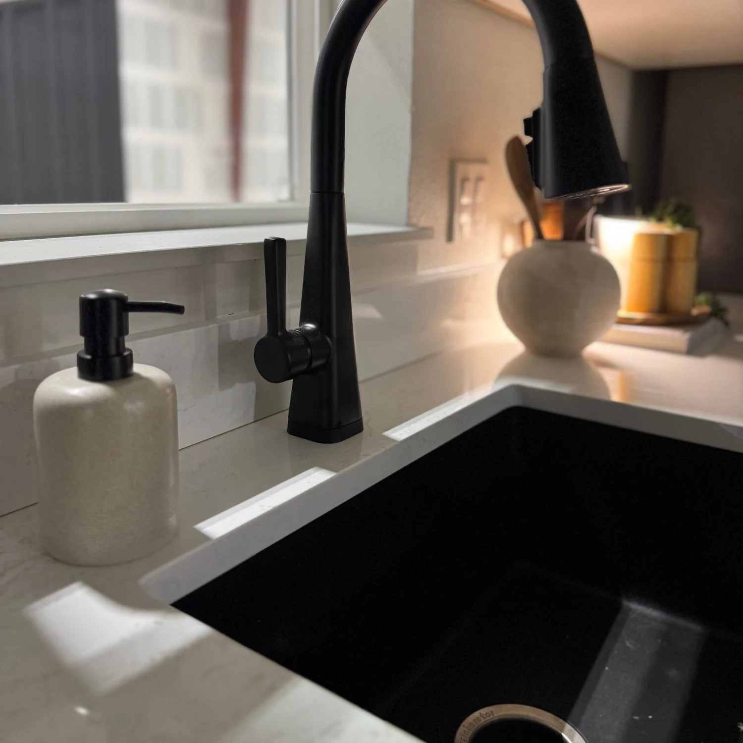 Black pull-down kitchen faucet above a matching sink