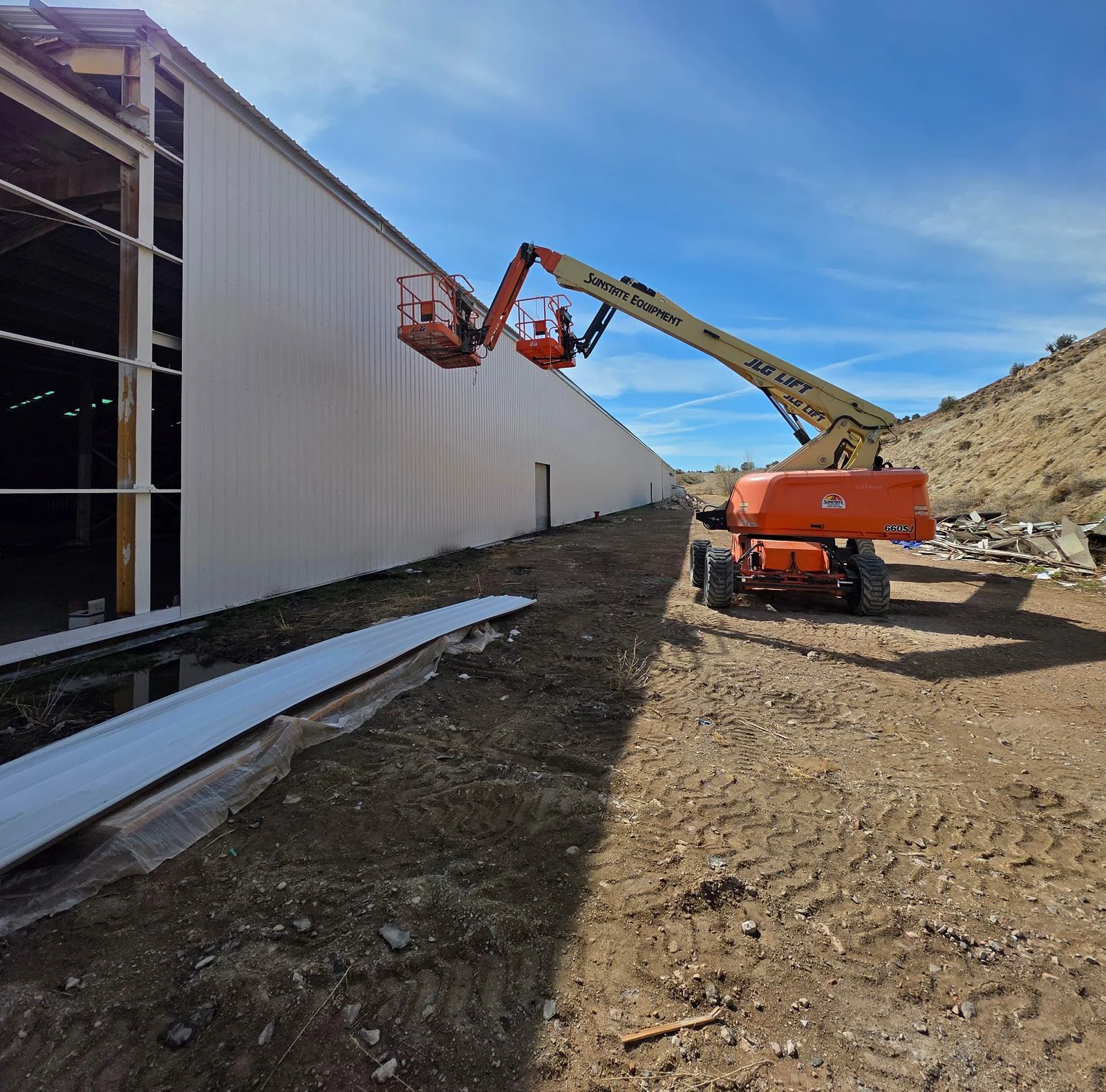 New exterior factory walls beside a boom lift
