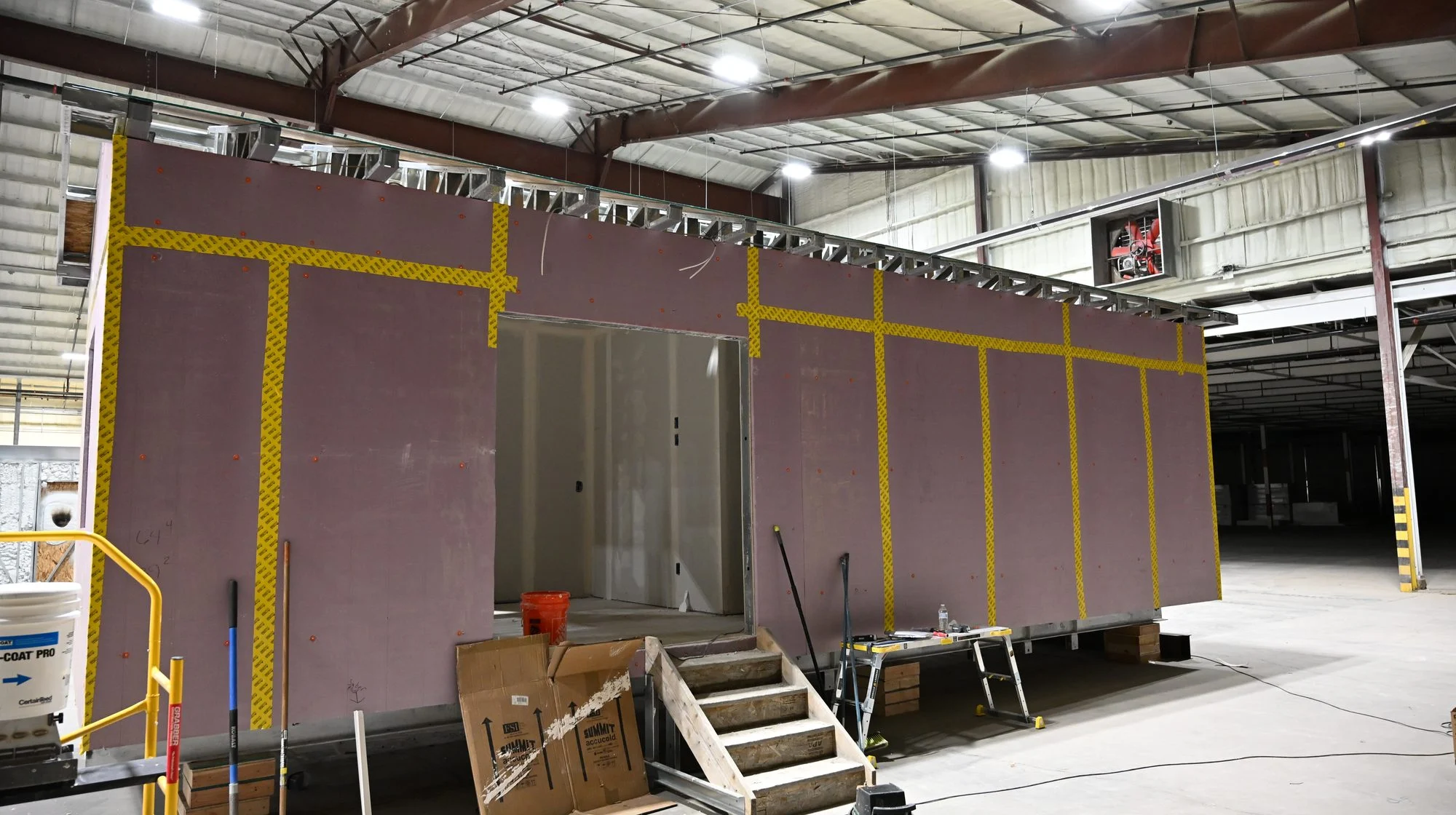 Cabin exterior wrapped in rigid foam panels with taped seams