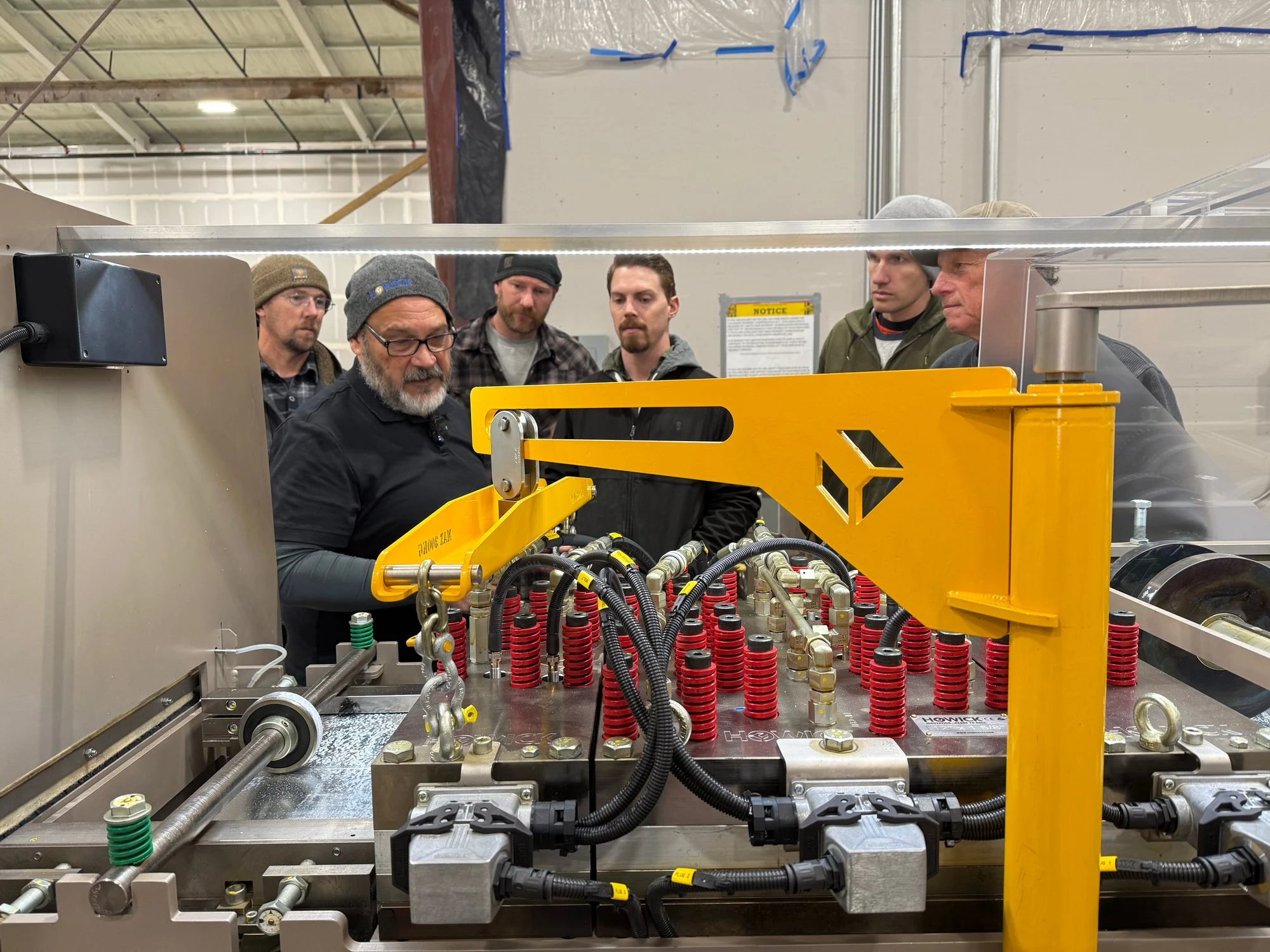 Mytikas crew gathered around a Howick machine during training