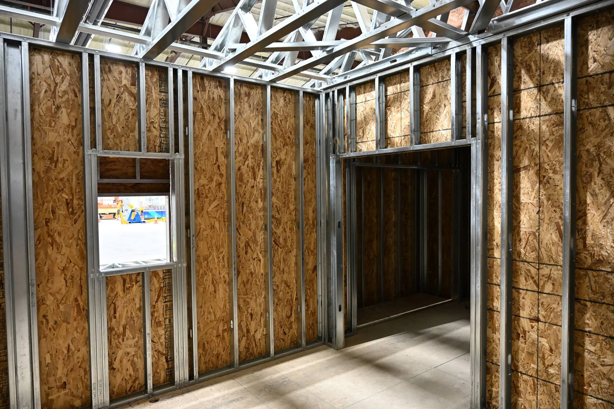 Steel wall studs and roof trusses inside a framed building
