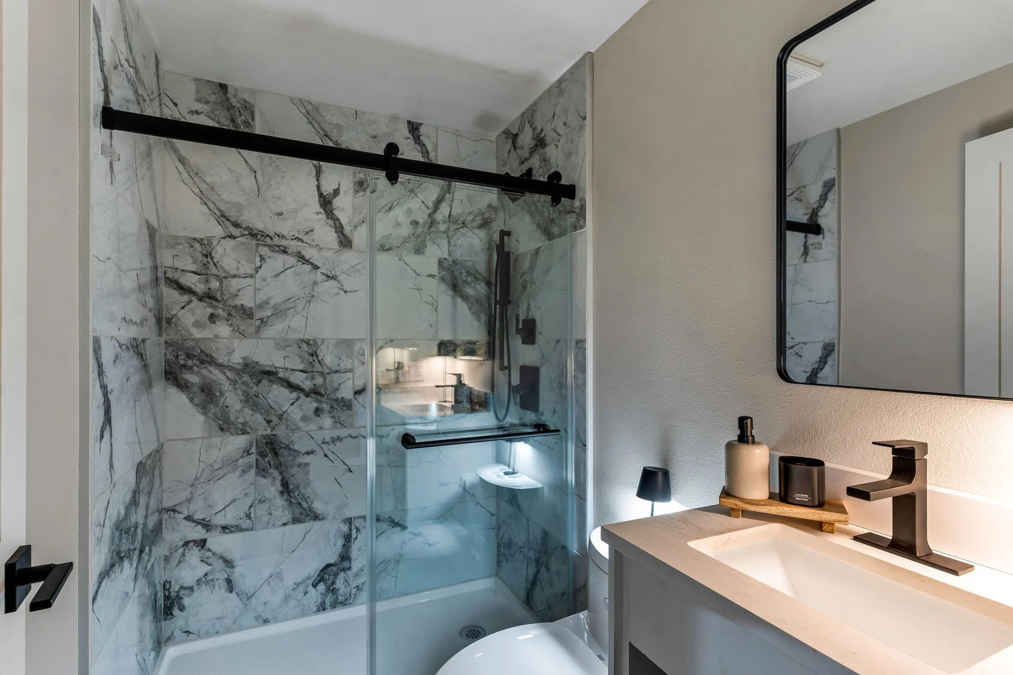 Basecamp bathroom with a glass shower and black fixtures
